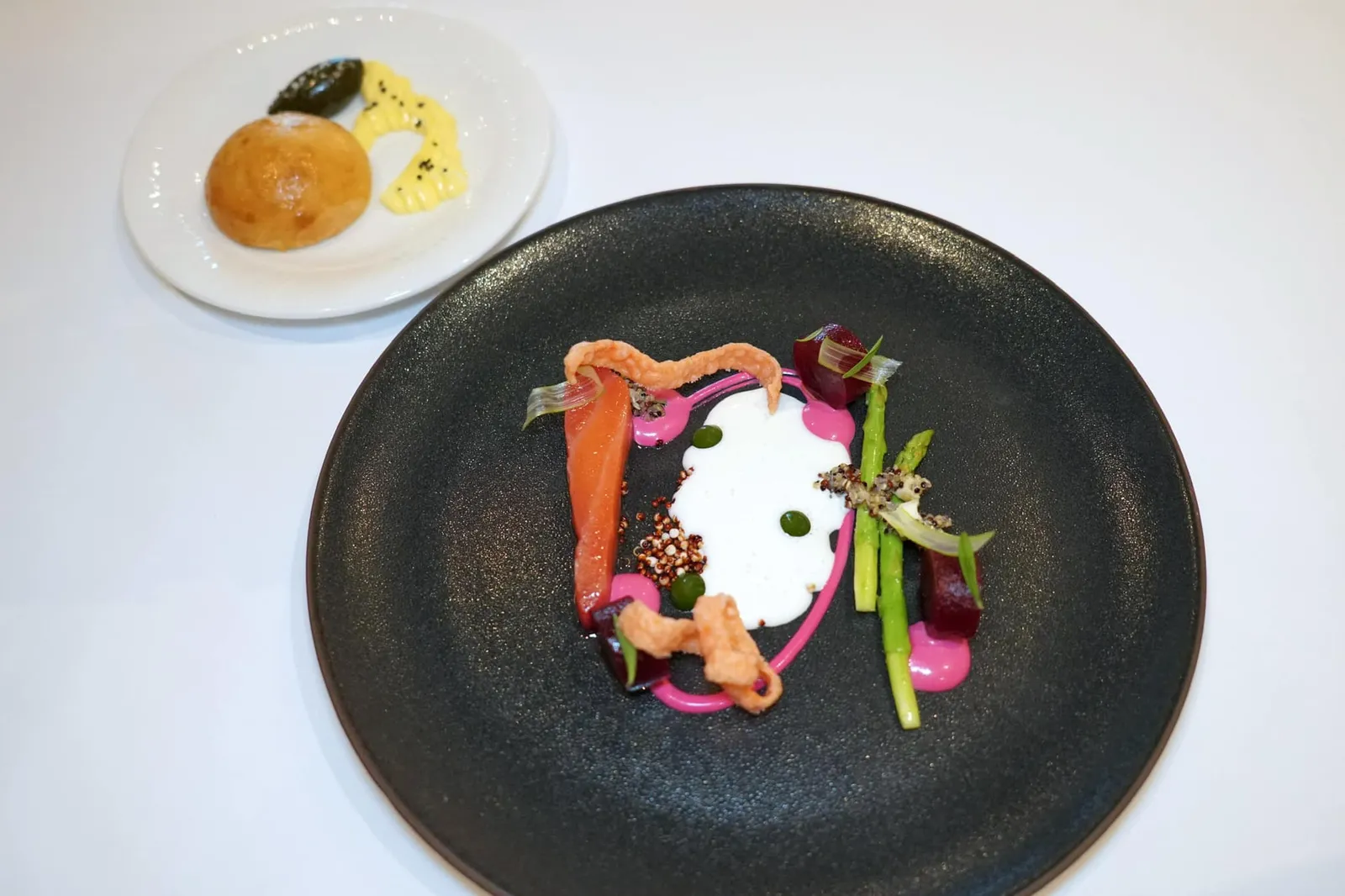 TASMANIAN SALMON beet root | asparagus | apple พระเอกของจานนี้คือ “ปลาแซลมอน” นำเข้าจากหมู่เกาะ Tasmania ประเทศออสเตรเลียแล่ออกมาเป็นฟิเลท์แล้วไปหมักกับขิง บีทรูท และตะไคร้ จากนั้นนำไปซูวีที่อุณหภูมิ 43 องศาเซลเซียสซึ่งเป็นอุณหภูมิที่ทำให้เนื้อปลาสุกแต่ยังคงความฉ่ำจากไขมันเอาไว้ได้อย่างครบถ้วน องค์ประกอบข้างกันคือพูเรบีทรูทสีชมพู ชิ้นบีทรูท และบีทรูทชิปส์ ยังมีหน่อไม้ฝรั่ง สลัดควินัว และ Terragon gel ที่โต๊ะพนักงานจะเทราด Apple cream สีขาวลงไปตรงกลางจาน จานข้าง ๆ เป็นขนมปังบริยอชอันเลื่องชื่อที่เชฟแดนจัดเสิร์ฟมาตั้งแต่ร้านเดิมที่ Upstairs at Mikkeller แต่เปลี่ยนองค์ประกอบเคียงต่าง ๆ ให้หมุนเวียนไปไม่ซ้ำกัน (16/20)