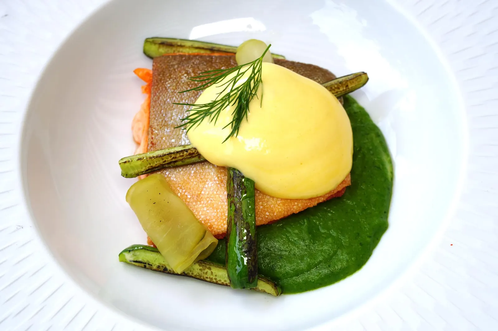 Char Watercress | Cucumber | Yuzu Hollandaise “ชาร์” เป็นปลาจำพวกแซลมอน (Family Salmonidae) แต่จะมีอัตราส่วนไขมันที่พอเหมาะทำให้เนื้อสัมผัสดีกว่าแซลมอนนอร์เวย์ที่เราคุ้นเคยกัน เชฟแพนเซียมาสุกกำลังดี ด้านบนคือซอสฮอลันเดสซึ่งเป็น Signature Sauce ของเชฟ Stefan Jäckel เราประทับใจมากที่เชฟสามารถใส่รสชาติเปรี้ยวของยูซูลงไปเบา ๆ ทำให้โทนรสชาติโดยรวมไม่เลี่ยนโดยง่าย ด้านล่างคือพูเรวอร์เตอร์เครส ข้างกันคือแตงกวาย่างกรอบ ๆ และแตงกวาฝานบาง ๆ แล้วหมักในน้ำยูซูจนมีรสชาติอมเปรี้ยวกำลังดีม้วนมาดูสวยงาม สำหรับซอสฮอลันเดสใครที่อยากชิมเวอร์ชั่นเต็มสามารถสั่งจากเมนูแบบ À La Carte ได้อีกด้วย (15/20)