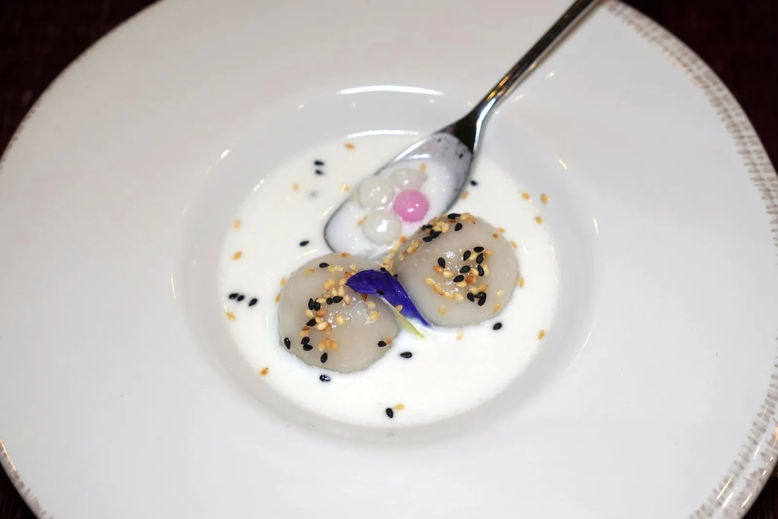 🥄 DESSERT กรานิต้าและขนมโค Dessert of the day ขนมโคน้ำกะทิเป็นของหวานยอดนิยมในพิธีประเพณีแรกนาขวัญ เชฟปั้นลูกขนมโคมาในขนาดพอดีคำ ตรงกลางสอดไส้ที่ได้จากการมะพร้าวทึนทึกอัมพวาไปเคี่ยวกับน้ำตาลโตนดเมืองเพชรจนให้รสชาติหวานที่มีมิติ น้ำกะทิรอบ ๆ ให้รสชาติหวานที่พอเหมาะเพื่อไม้ให้บดบังความโดดเด่นของไส้ขนมโค ด้านล่างมีบัวลอยนุ่มหนึบใส่มาด้วย จากนั้นจบด้วยการโรยงาขาวและงาดำลงไปเสริมกลิ่นหอมชวนหลงไหลเป็นที่สุด (15/20)