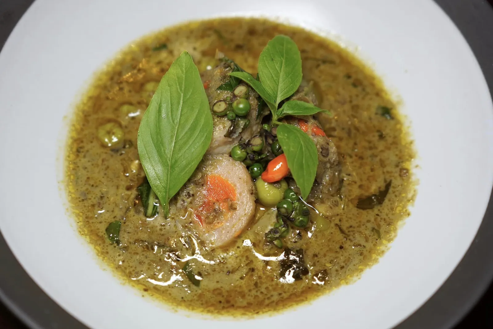 🥄 MAIN COURSE แกงระแวงปลากรายไข่ครอบ Songkhla salted egg fish ball in green curry “แกงระแวง” เป็นเมนูอาหารไทยโบราณตำรับชาววังที่มีลักษณะคล้ายกับแกงเขียวหวานเข้มข้น สูดลมหายใจลึก ๆ จะสัมผัสได้ถึงอโรมาหอม ๆ และความกรอบของลูกพริกไทยผสานไปกับความกรอบของมะเขือพวง ตัวแกงมีสีเขียวเหลืองจากขมิ้น สำหรับอีกหนึ่งประกอบคือไข่ครอบนั้นมีที่มาจากจับหวัดสงขลาโดยเชฟจะคัดเฉพาะส่วนไข่แดงของไข่เป็ดไปดองในน้ำเกลือห่อหุ้มรอบ ๆ ด้วยลูกชิ้นปลากรายนุ่มเด้งเข้ากันกับข้าวหอมมะลิร้อน ๆ ได้อย่างไร้ที่ติ (16/20)