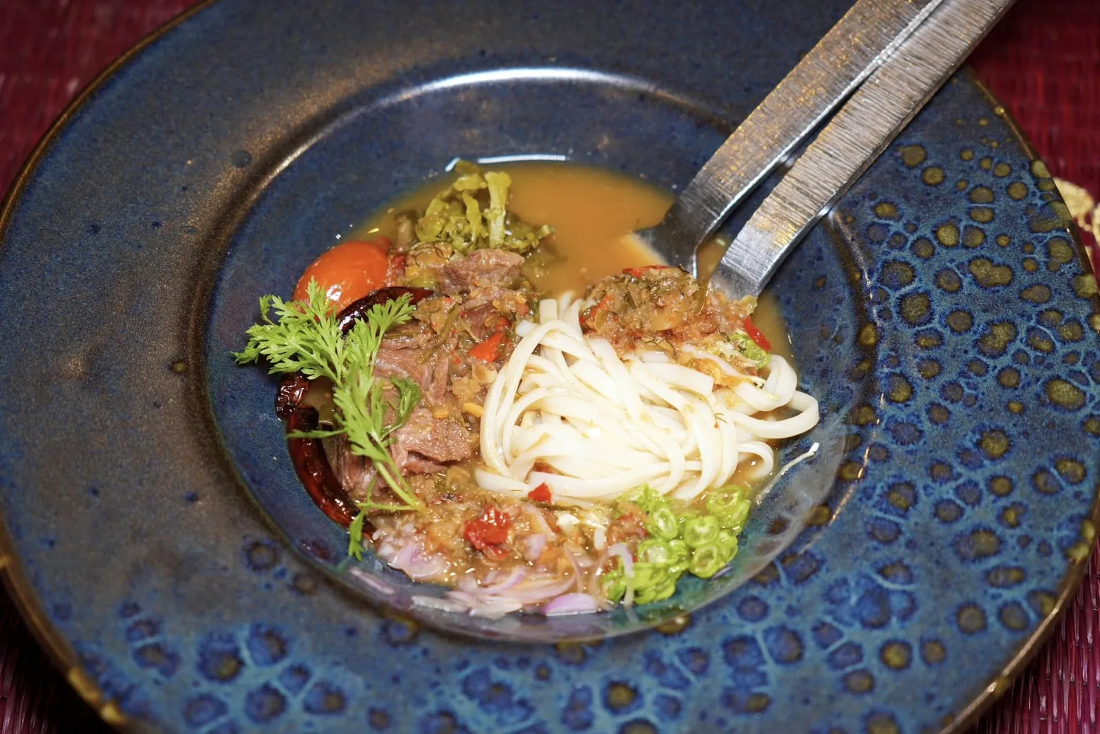 🥄 PRE-MAIN COURSE อ่อมงัวข้าวปุ้น Rice noodle with Isaan beef curry broth เราสามารถสัมผัสได้ถึงรสชาติที่เผ็ดจัดจ้านจากพริกและความกรอบที่หลากหลายจากผักเคียงต่าง ๆ นอกจากนี้ด้านล่างยังมีเส้นข้าวปุ้นมีลักษณะคล้ายขนมจีนนุ่ม ๆ อีกเช่นกัน (15/20)