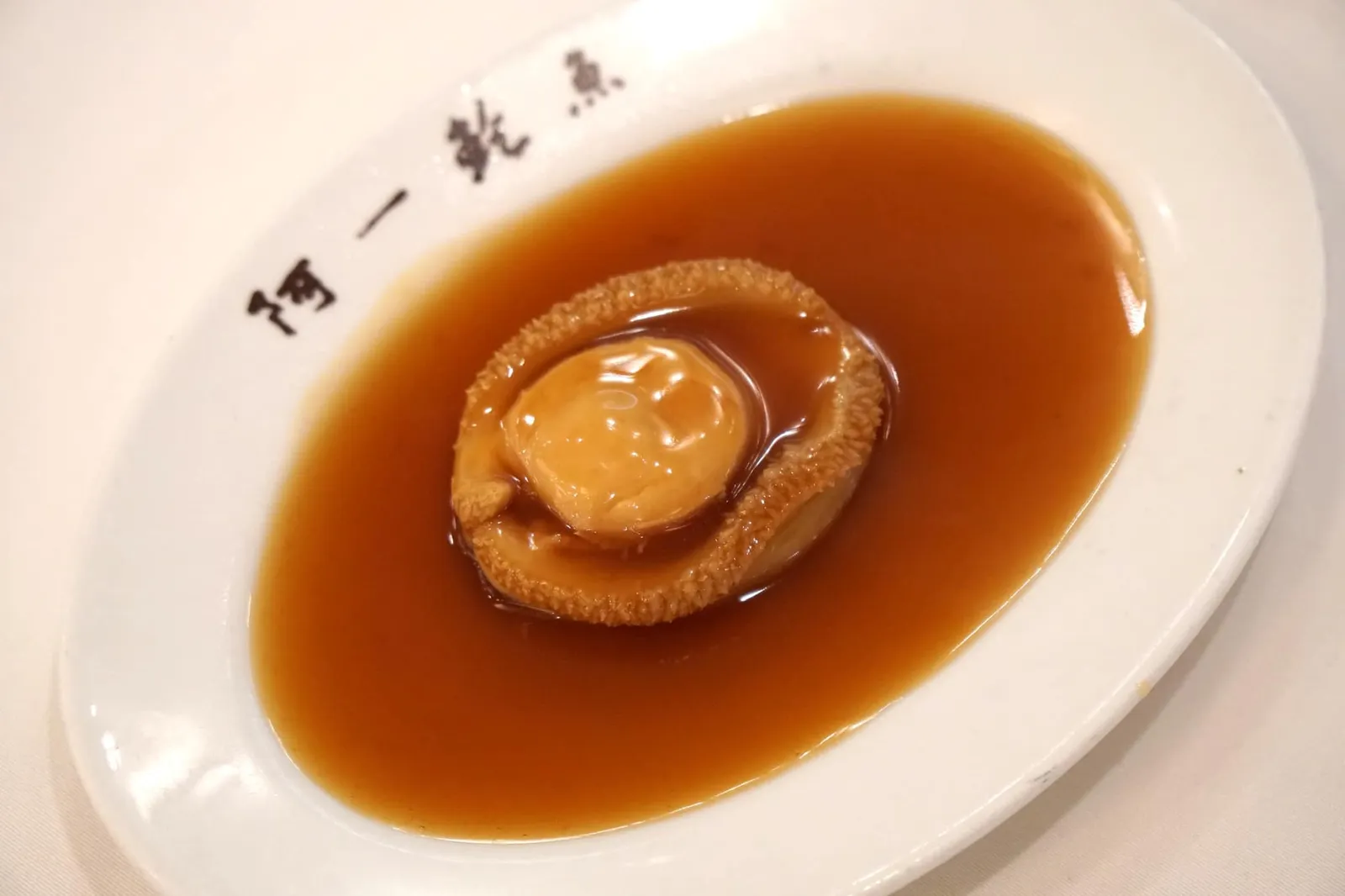 เปาฮื้อสดแอฟริกาทั้งตัว (4หัว) น้ำแดง (1,800++) Stewed Whole 4PPC South African Fresh Abalone สำหรับเมนูหอยเปาฮื้อลูกค้าสามารถเลือกทาน "อายัทเปาฮื้อสดตุ๋น" สูตรคลาสสิค หรือจะเป็น "เปาฮื้อสดน้ำแดง" ก็อร่อยไม่แพ้กัน เเละยังเลือกหอยเปาฮื้อได้ทั้งเเบบสดที่จะมีเนื้อสัมผัสเด้ง นุ่ม หรือหอยเปาฮื้อแบบแห้งที่จะมีเนื้อสัมผัสเคี้ยวหนึบ มีความอุมามิมากกว่า โดยสาขากรุงเทพจะมีราคาเริ่มต้นอยู่ที่ราวๆ 600 กว่าบาทเท่านั้น เเต่เราขอเเนะนำให้สั่งขนาดที่ใหญ่ขึ้นมาสักหน่อย เพื่อรสชาติเเละเนื้อสัมผัสที่เหมาะสม (16/20)