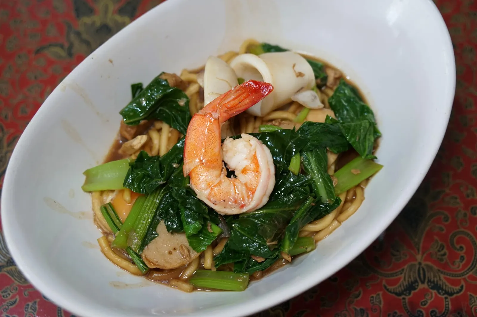 หมี่สะปำ ใส่ไข่ (65) Stir fried Hokkien noodle with seafood สะปำเป็นชื่อหมู่บ้านเล็กๆในตำบลเกาะเเก้ว จังหวัดภูเก็ต อาม่าเจียรมีพี่น้องทำอาชีพประมงเเต่ครอบครัวอาม่าเปิดร้านขายของชำและทำอาชีพเสริมคือผัดหมี่ฮกเกี้ยน เส้นหมี่ของอาม่ามีเนื้อสัมผัสเเละรสชาติที่เป็นเอกลักษณ์แตกต่างจากบริเวณอื่นจนทุกคนต่างพูดกันปากต่อปากว่า มาทาหมี่ผัดที่สะปำ ก่อนที่จะเรียกกันสั้นลงว่ามาทานหมี่สะปำในที่สุด (13/20)