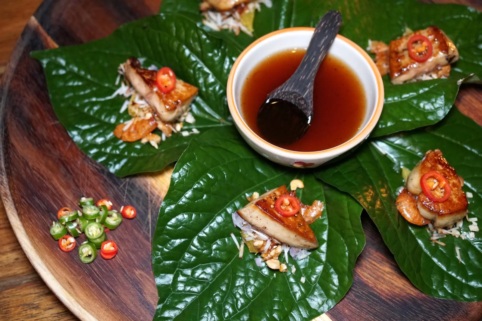 เมี่ยงตับห่าน (450++) Signature foie gras in betal leaf wrap, ginger, cashew nuts candy, sweet and sour dip สุดยอดจาน Signature Dish ที่ดีที่สุดในวันนี้เเละเป็นจานเเรกที่เราได้ทานคือเมี่ยงตับห่าน ที่มาที่ไปของจานนี้เกิดขึ้นจากการที่เชฟหน่อยได้ทานเมี่ยงคำแบบปกติเเล้วรู้สึกว่ามีรสชาติบางอย่างขาดไป จึงได้ลองนำฟัวกราส์มาใส่ดู ผลปรากฎว่าเนื้อสัมผัสเเละความครีมมี่ของฟัวกราส์สามารถเข้ากันได้ดีกับเครื่องเมี่ยงอื่นๆคือมะพร้าวคั่วเเละมะม่วงหอมพานต์คั่วได้อย่างน่าตกใจ กลิ่นของฟัวกราส์ที่เรากลัวว่าจะเด่นเกินหน้าเกินตาจนกลบความเป็นเมี่ยงแบบไทยๆกลับถูกบดบังด้วยพริกซอย, รสเปรี้ยวของมะนาว และซอสเมี่ยงคำที่ปรับรสมาอย่างดี ขอย้ำว่าต้องใส่พริกซอยที่ร้านใส่มาข้างๆเพิ่มลงไปด้วย (15/20)