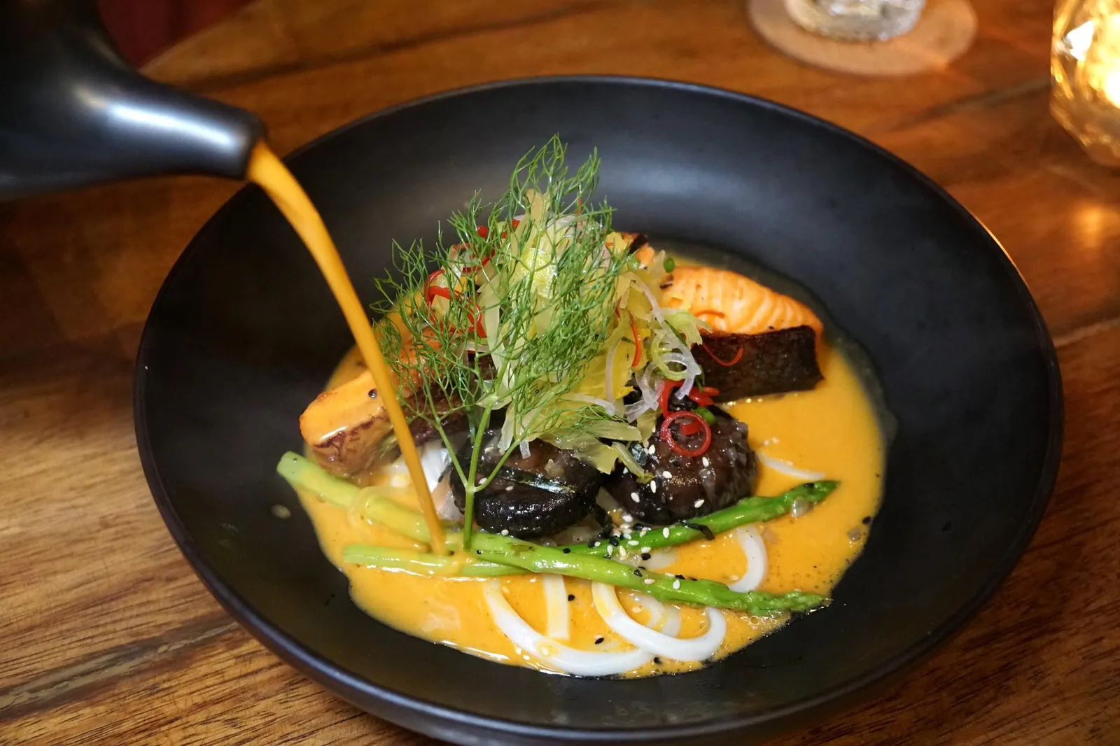เส้นอุด้งปลาแซลมอนราดน้ำข้าวซอย (450++) Charcoal grilled salmon steak, yellow curry from Chiang Mai, Udon noodles จานถัดมาพนักงานจะนำสเต๊กปลาเเซลมอนมาเสิร์ฟพร้อมเทซุปน้ำข้าวซอยลงต่อหน้าลูกค้า (12/20)