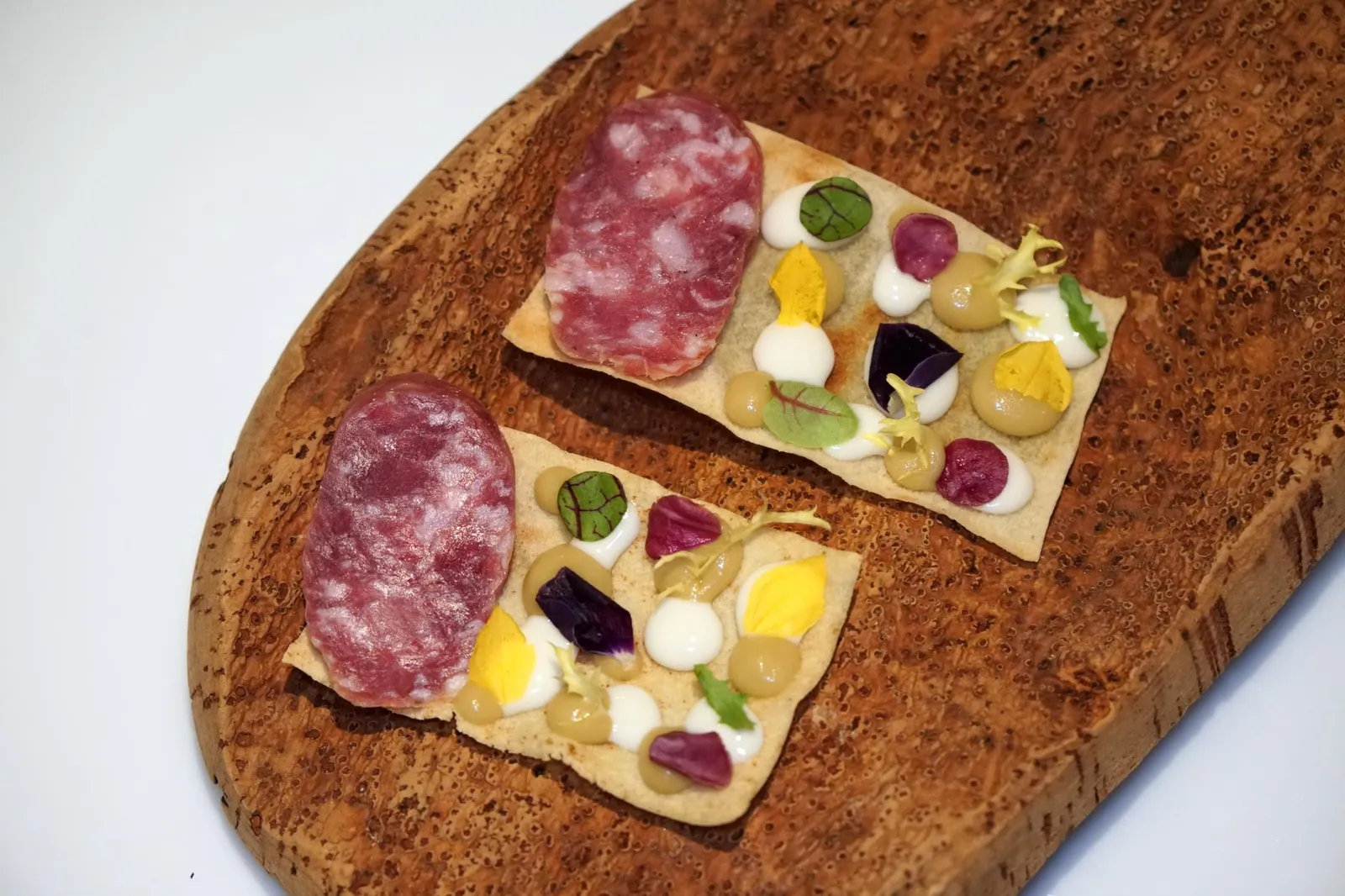 Amuse-bouche Sardinia snack ถัดมาคือของว่างที่เรียกว่า “ซาดิเนียสเเน็ค” เชฟใช้ขนมปังคาราเซากรอบมารองด้านล่าง ด้านบนมีพูเรสีขาวทำมาจาก Pecorino cheese พูเรสีเขียวทำมาจาก Green olive ยังมี Salami ชิ้นโตซึ่งเป็นพระเอกให้เนื้อสัมผัสที่ต้องเคี้ยวเล็กน้อย มีรสชาติเค็มปนอุมามิและช่วยเรียกน้ำย่อยได้ดี ชิ้นนี้เชฟ Alessandro ได้รับเเรงบันดาลใจมาจากคนเลี้ยงเเกะในเเคว้น Sardinia ซึ่งต้องจัดเตรียมอาหารเเห้งสำหรับเดินขึ้นบนเขาหลายวัน (15/20)