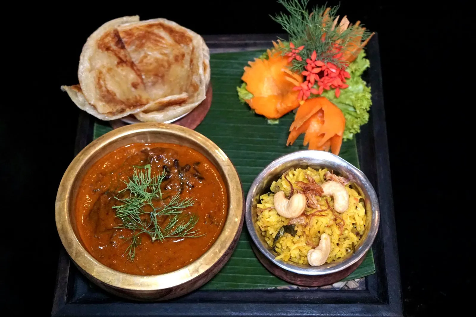 แกงสิงหลแก้มวัว ข้าวหมก โรตี (780++) SING HON CHAROLAIS BEEF CHEEK Influenced by Sri Lanka and dating back to the reign of King Rama II. Charolais beef cheek - Stewed in Coconut Milk - Organic Herbs Cinnamon - Unique Turmeric Rice - Roti - Organic Mini Cucumber Salad ด้วยความที่เราเคยทานเมนูเเนะนำอย่าง "แกงมัสมั่นแกะ โรตี ข้าวหอมมะลิ" และ "แกงคั่วปูใบชะพลู ชะคราม เส้นหมี่" ไปที่สาขากรุงเทพเเล้ว วันนี้จึงมีโอกาสได้ลองทานเมนูที่ไม่ค่อยได้สั่งในร้านอื่นอย่าง "แกงสิงหล" ซึ่งเป็นแกงที่ชาวพื้นเมืองประเทศศรีลังกาอย่างชาวสิงหลที่นิยมทำเพื่อเฉลิมฉลองในโอกาสพิเศษ ครั้นชาวสิงหลอพยพเข้ามาในกรุงรัตโกสินทร์ในสมัยสมัยพระบาทสมเด็จพระพุทธเลิศหล้านภาลัย รัชกาลที่ 2 ที่ได้นำเมนูนี้ติดตัวมาด้วยนั่นเอง สำหรับใครที่กลัวว่าแกงจากประเทศศรีลังกาดูน่ากลัว ไม่คุ้นเคย หรือแก้มวัวจะทานยาก มีกลิ่น เราอยากบอกว่าเวลาไปร้านอาหารไทยทั่วๆไปเราก็เราก็เป็นเหมือนกัน เเต่ขอให้มั่นใจกับฝีมือการทำแกงของเชฟนูรอเเล้วลองชิมดูสักครั้ง เนื้อแกงเนียน ละเอียดมากๆ มีความนุ่มของกะทิเคล้ากันกับกลิ่นสมุนไพร รสชาติเปรี้ยวเค็มหวานปรุงออกมาบาลานซ์กันอย่างไร้ที่ติ โปรตีนหลักอย่างแก้มวัวพันธุ์ชาร์โรเล่ส์ถูกตุ๋นจนนุ่ม ส่วนไขมันที่แทรกอยู่ในเเก้มวัวไม่เละจนเกินไป สุดยอดมากๆ (16/20)