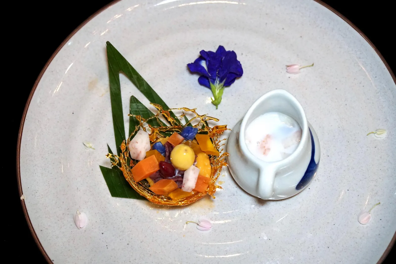 ตูโบ้ (380++) TUBO Baba heritage recipe ! - Andaman bird’s nest - Adzuki beans - sweet potato - taro - gingko - coconut cream Tubo is a family gathering Phuketian dessert! เเต่ใครที่มาทานสาขาภูเก็ตขอเเนะนำให้สั่ง “ตูโบ้” หรือ “โบโบ้จาจา” ขนมพื้นเมืองที่หาทานได้เฉพาะสาขานี้เท่านั้น จานดั้งเดิมเป็นต้มบวดรวมมิตรที่มีส่วนผสมของถั่วแดงเม็ดเล็ก (ถั่วย้อแย้) มันเทศ เผือก (หัวบอน) และแป้งมัน (แป้งตั้วจูหุ้น) สำหรับรูปแบบการนำเสนอของเชฟนูรอคือการเเยกเครื่องเสิร์ฟมาในตาข่ายคาราเมล ให้หยิบน้ำกะทิที่เติมน้ำตาลและเกลือในถ้วยที่วางอยู่ข้างกันราดลงไป ถือเป็นขนมไทยโบราณที่ทำออกมาได้น่าสนใจ (13/20)