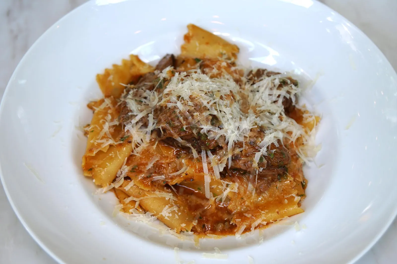 Pappardelle con Guancia di Manzo (535++) Handmade pasta with slow cooked Wagyu beef cheek สำหรับพาสต้าจานเเรกเป็นพาสต้าเส้นปัปปาเดลเล่เส้นสดที่ร้านทำเองทั้งหมดตั้งเเต่ขั้นตอนการนวดแป้งเสิร์ฟมาที่ความสุกระดับ Al Dente พอดิบพอดี เส้นพาสต้าได้รูปและหนาเท่ากันทั้งหมด ทานกับซอสรากูแก้มวัวที่ถูกตุ๋นจนเปื่อยนุ่ม จานนี้กลิ่นของเนื้อวัวค่อนข้างเด่นชัดมากๆ ก่อนทานพนักงานจะมาขูดพาเมซานโรยลงไปด้านบนเพื่อให้มีรสเค็มเบาๆ ตอนเราทานคุณผู้จัดการแอบเดินมากระซิบว่าจานนี้คือ Best Seller ของทางร้านเลยล่ะ (13/20)