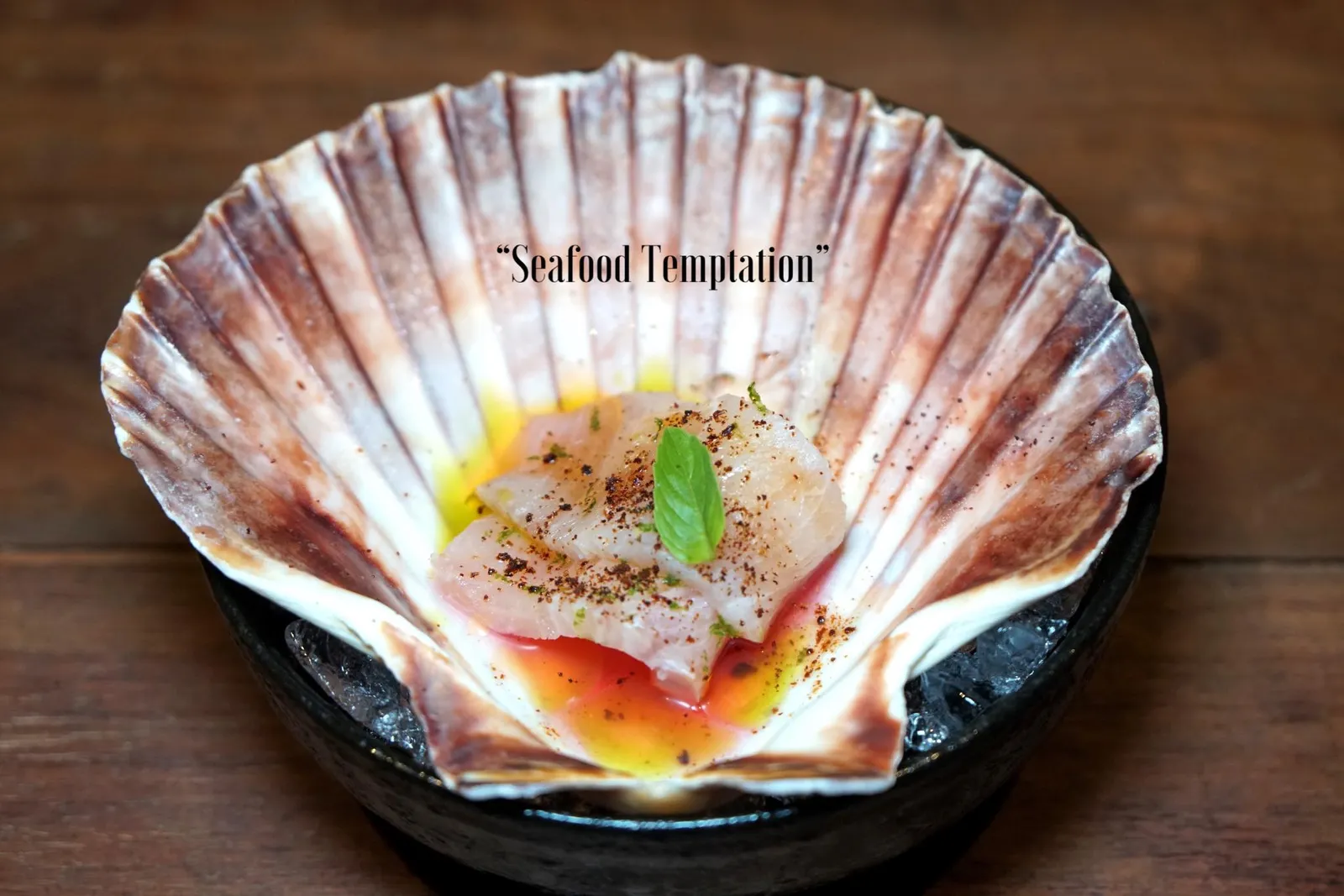 SEAFOOD TEMPTATION “ปลาช่อนทะเล” จานนี้เชฟได้มาจากชุมชนชาวประมงจังหวัดชุมพร สไลด์เป็นชิ้นบางๆแบบซาชิมิ มีเนื้อสัมผัสเคี้ยวหนึบเเต่ไม่เหนียว ด้วยความที่เป็นปลาเนื้อขาวทำให้รสชาติของปลาช่อนทะเลไม่ได้เด่นชัดเเต่รสชาติหลักๆของจานนี้มาจากน้ำซอสสีชมพูดด้านล่างซึ่งได้มาจากการหมักลูกมะเม่า ผลไม้ป่าชนิดหนึ่งมีสีแดงไปจนถึงดำ มีรสชาติเปรี้ยวปนเค็มนิดๆซึ่งเป็นรสเฉพาะตัวของพืชชนิดนี่ เชฟหยดน้ำมันใบโหระพาที่ได้จากสวนข้างๆร้านลงไปด้วยเพื่อเชื่อมรสชาติที่เด่นชัดของมะเม่าให้เข้ากันกับองค์ประกอบอื่นๆ ผงด้านบนคือ Sun-dried tomato powder ให้รสชาติเปรี้ยวอุมามิ (13/20)