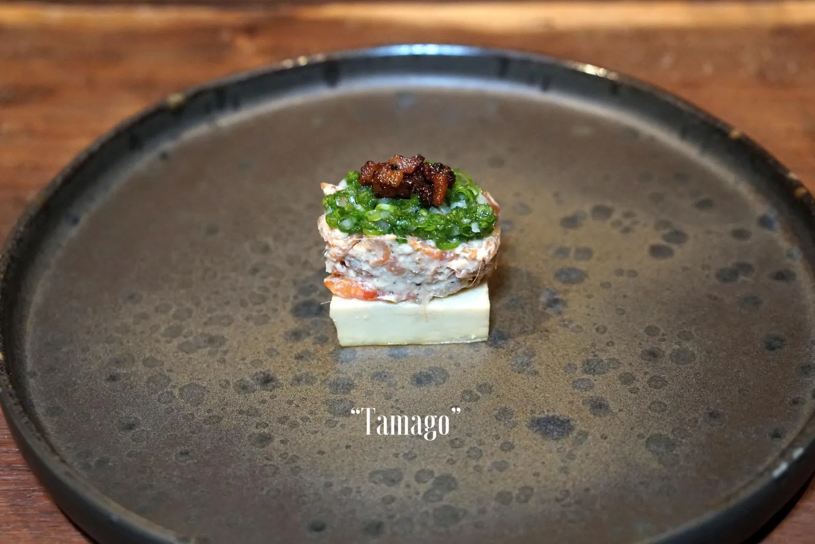TAMAGO จานนี้คือ “ทามะโกะ” หรือไข่หวานที่เชฟผสมเนื้อของปลาดุกนาเข้าไปด้วยเพื่อให้มีรสหวานนิดๆ เลเยอร์ตรงกลางคือกุ้งฝอยจากจังหวัดเชียงรายปรุงรสด้วยครีมข้าวโพดรมควัน ทอปด้วยชั้นบนสุดคือยำต้นหอมเเละเบคอน ไข่หวานมีเนื้อสัมผัสนุ่มคล้ายเต้าหู้ ครีมข้าวโพดมีกลิ่นหอม มีรสหวานเบาๆเข้ากันได้ดีกับกลิ่นของต้นหอม เบคอนมีรสเค็มกรอบเพื่อตัดรสชาติเเละเนื้อสัมผัสขององค์ประกอบอื่นๆที่กล่าวมา (12/20)