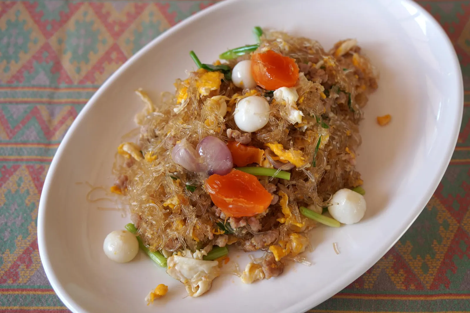 ผัดวุ้นเส้นไข่เค็ม (90) Stir-fried cellophane noodle with salted egg and savory pork จานนี้เขียนเอาไว้ตัวโตๆในสมุดเมนูว่า Signature Dish บอกเลยว่าใครไม่สั่งถือว่ามาไม่ถึงบ้านสวนแม่ริม ส่วนที่มาของต้องย้อนไปสมัยที่คุณหนอเปิดร้าน Lemon Tree สาขาห้วยแก้ว เมื่อหม่อมถนัดศรีต้นตำรับเชลล์ชวนชิมท่านได้เเวะมาทานอาหารที่ร้านและได้มอบป้ายเชลล์ชวนชิมให้กับสาขาห้วยแก้วด้วย นอกจากนี้ท่านยังได้เเนะนำสูตรของเมนูนี้ให้กับคุณหนอพร้อมทั้งค่อยๆปรับสูตรจนเข้าที่ เริ่มจากการนำวุ้นเส้นไปผัดกับไข่เค็มในกระทะความร้อนสูงโดยมีโปรตีนหลักคือหมูสับ ใส่หอมแดงเเละกระเทียมโทนลงไปด้วย วุ้นเส้นที่นี่จะติดกันเป็นก้อนเล็กๆหนึบๆเเต่ไม่เหนียว ทานเเล้วมีกลิ่นหอมไข่เเละได้ความมันจากไข่เค็ม บอกเลยว่าต้องมาลองเอง (13/20)