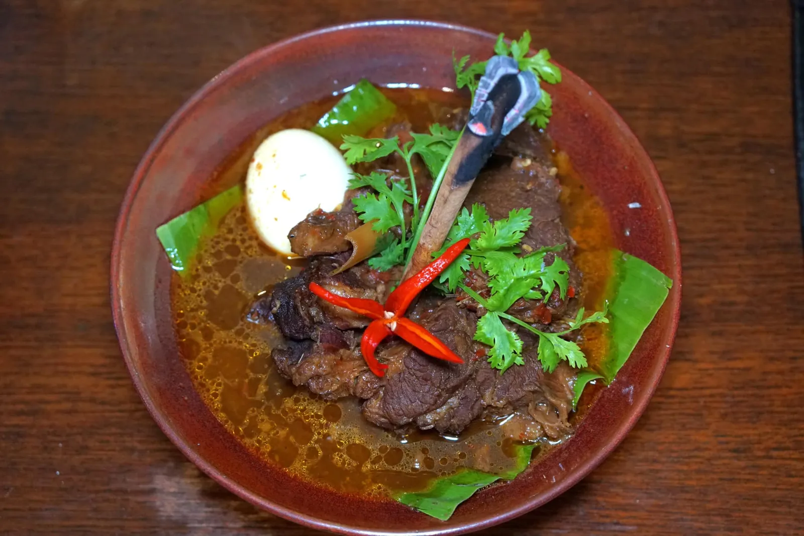 สันคอหมูพะโล้ต้มยำ (299) Pork in Tom Yum Brown Sauce จานนี้เชฟลันไดนำเมนูอาหารพื้นบ้านอย่างพะโล้มาเพิ่มเติมรสชาติเผ็ดจัดจ้านครบเครื่องต้มยำ มีทั้งข่า ตะไคร้ ใบมะกรูด พริก มะนาว แต่ยังไม่ทิ้งความหวานและอโรม่าของอบเชยและโปยกั๊กแบบพะโล้ เนื้อหมูส่วนสันคอตุ๋นมา 3 ครั้งจนนุ่ม ด้านบนเป็นธูปที่จุดมาตอนเสิร์ฟช่วยเพิ่มกลิ่นหอมให้ชัดเจนและน่าทานมากขึ้น (13/20)