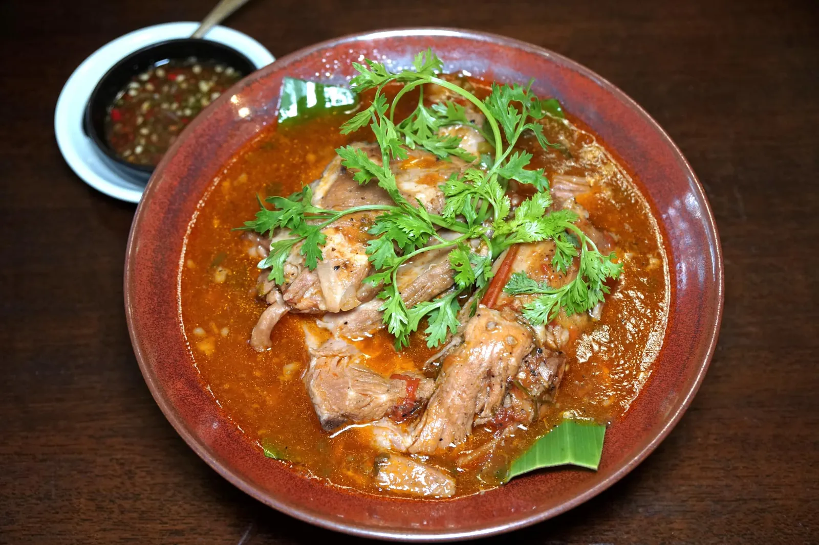 ซี่โครงหมูอบซอสไวน์แดง (329) Pork Ribs With Red Wine Sauce แม้จะเป็นร้านอาหารไทยแต่เราขอยืนยันว่าหนึ่งในเมนูที่ทำออกมาได้ดีที่สุดของวันนี้คือซี่โครงหมูที่ผ่านการตุ๋นถึง 3 ครั้งจนเปื่อยนุ่ม เพียงใช้ช้อนส้อนดันเบาๆเนื้อก็ร่อนออกจากกระดูกโดยง่าย น้ำซอสรสชาติกลมกล่อม จานนี้เชฟลันไดได้แรงบันดาลใจมาจากเมนูกับแกล้มสมัยทำงานออฟฟิศ จะทานเปล่าๆแบบอาหารฝรั่งหรือทานกับซอสรสชาติจัดจ้านแบบคนไทยก็เด็ดไม่แพ้กัน (14/20)
