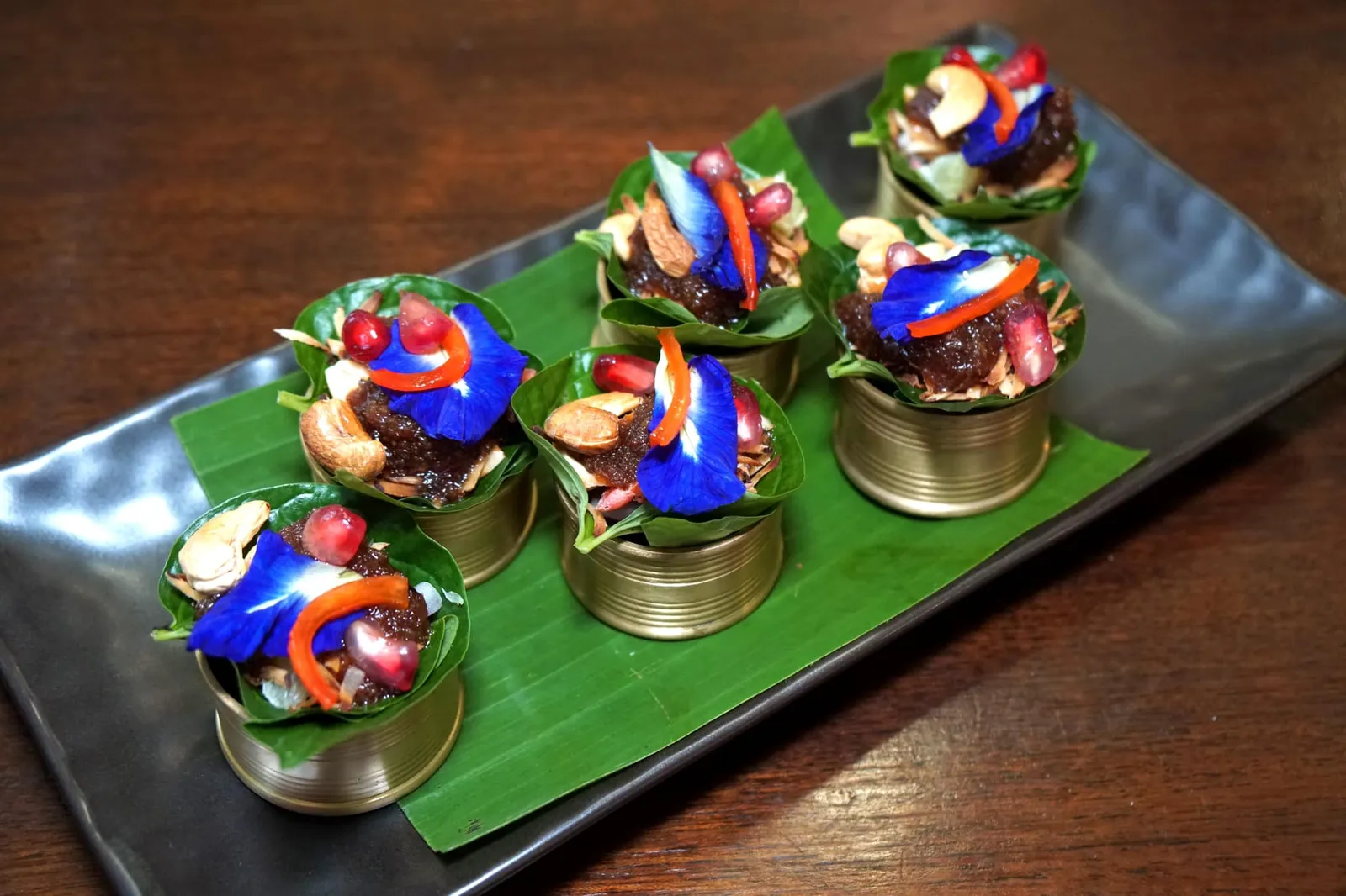 เมี่ยงคำดอกไม้ (139) Leaf Wraps: Blend of Coconut, Ginger, Fresh Bitter Leaves, Peanut, Lime and Chilli เริ่มต้นมื้ออาหารด้วยชุดเมี่ยงคำที่เชฟห่อมาให้เสร็จสรรพในใบชะพลู ด้านในเป็นเครื่องเมี่ยงประกอบด้วยดอกไม้หลายชนิด เมล็ดมะม่วงหิมพานต์ ทับทิม มะพร้าวซอยคั่ว ขิงซอย มะนาว และน้ำซอสรสเด็ด (13/20)