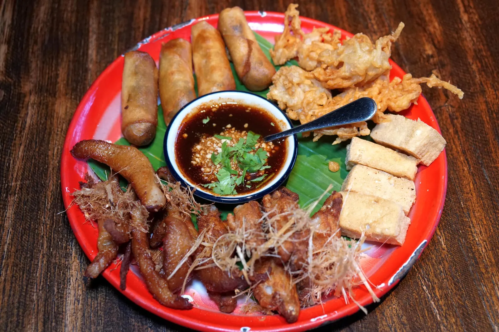 ออเดิร์ฟรวม (350++) Thai appetizer platter เราแนะนำให้เริ่มมื้ออาหารด้วยออเดิร์ฟรวมเพื่อให้ได้ทานอาหารว่างหลากหลายอย่าง เสิร์ฟมาในถาดขนาดสำหรับทานได้ 2-3 คนมีทั้ง … “ปอเปี๊ยะทอด” ที่ด้านในเป็นไส้ผัก ผิวด้านนอกบางกรอบ ไม่อมน้ำมัน “เผือก + เต้าหู้ทอด” เผือกทอดออกมาได้กรอบ เคี้ยวง่ายไม่ติดฟัน เสิร์ฟมากับเต้าหู้ที่ทางร้านทำเองมีเนื้อสัมผัสที่นุ่มอร่อย มีความเบา กัดแล้วไม่แน่น ไม่เหนียว “คอหมูหมักข่าทอด” จัดว่าเป็นไอเทมที่เด็ดที่สุดในจานเพราะทางร้านหมักออกมาได้นุ่มมาก มีกลิ่นหอมเฉพาะตัว กัดแล้วมีความเด้งนิดๆ สุดยอดมากๆ ติดใจจนอยากสั่งจานแยกเลยล่ะ ”ปีกไก่ทอดตะไคร้” ปีกไก่ชิ้นจิ๋ว ทอดมาร้อนๆ เนื้อด้านในยังคงฉ่ำ ไม่อมน้ำมัน ดีงามมากๆ เรียกได้ว่าสั่งถาดเดียวแต่ได้ทานอาหารว่างที่เป็นเมนูแนะนำเกือบครบเลยล่ะ (13/20)