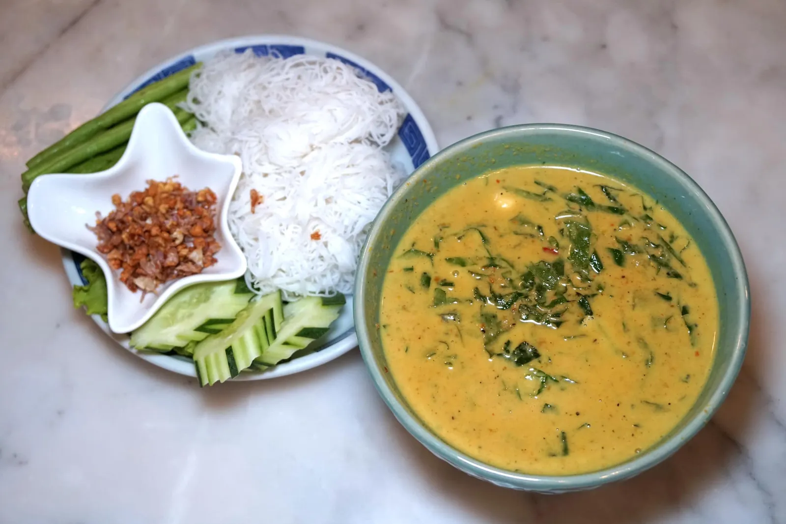 แกงปูใบชะพลู+หมี่ขาว (360) Crab Curry with Chapu Leaves Served with White Noodles มาร้านอาหารใต้บอกเลยว่าต้องแกงปูใบชะพลูเพราะอร่อยทุกร้าน สีเครื่องแกงที่นี่จะเข้มกว่าร้านอื่น เนื้อแกงเนียน ละเอียด มีรสเค็มนำตามด้วยความมันครีมมี่ของน้ำกะทิ มีกรรเชียงปูสดๆจากจังหวัดสุราษฎร์ธานีใส่มาให้พอสมควร แนะนำให้ตักราดบนเส้นหมี่ขาวแล้วโรยกระเทียมเจียวกรอบๆไว้ด้านบน นอกจากนี้ยังมีผักสดใส่มาให้เลือกทานคู่กันอีกด้วย (13/20)