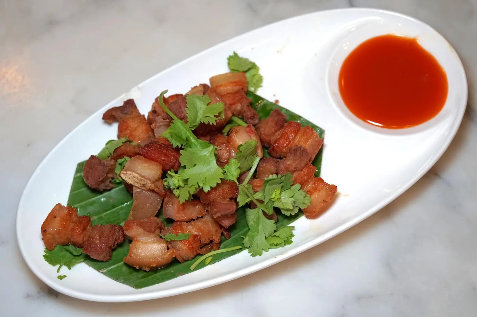หมูสามชั้นทอดน้ำปลา (180) Fried Streaky Pork with Fish Sauce ระหว่างรออาหารอยากแนะนำหมูสามชั้นทอดน้ำปลา ทางร้านใช้เนื้อหมูติดมันทอดจนสุกพอดี เนื้อยังคงนุ่ม ส่วนตรงชั้นไขมันยังมีความฉ่ำอยู่ ไม่อมน้ำมัน มีรสเค็มและกลิ่นหอมของน้ำปลาดี ทานกับซอสพริกศรีราชาเผ็ดหวานช่วยตัดความมันได้พอดี (13/20)