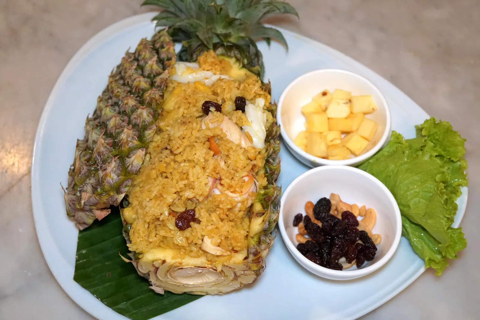 ข้าวผัดสับปะรด (290) Pineapple Fried Rice ข้าวผัดสับปะรดเป็นเมนูที่มีต้นกำเนิดมาจากเมืองภูเก็ตนี้เอง ทางร้านนำข้าวไปผัดกับเครื่องแกงกะหรี่จนหอม ตัดด้วยรสเปรี้ยวหวานของสับปะรดภูเก็ตซึ่งเป็นของดีประจำเมือง นอกจากนี้ยังมีลูกเกด เมล็ดมะม่วงหิมพานต์ กุ้ง หมู และหมึก อย่างไรก็ตามตัวข้าวทำมาแฉะไปนิดทำให้รสชาติถูกลดทอนลงมาอย่างน่าเสียดาย (11/20)