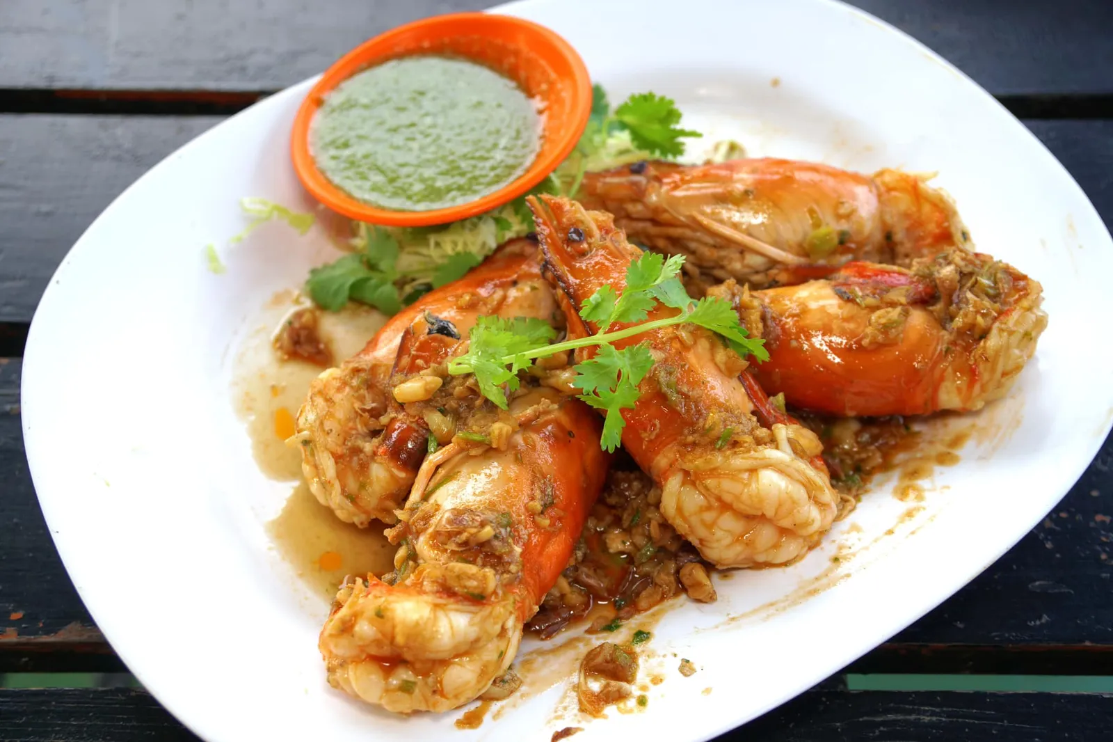 กุ้งแม่น้ำผัดซอสมันกุ้ง (400) สำหรับเมนูที่ได้รับการแนะนำจากมิชลินไกด์ คือกุ้งแม่น้ำเป็นๆที่ทีมครัวนำมาตัดแต่งแล้วพักเอาไว้ก่อน ในกระทะให้โยนกระเทียม พริกไทย และรากผักชีลงไปผัดตามด้วยมันกุ้งที่เตรียมเอาไว้ในฟรีซจนผสมเข้ากันดี จากนั้นใส่กุ้งแม่น้ำที่เตรียมเอาไว้ลงไปผัดให้ซอสเข้าเนื้อ ตอนทานให้ตักแยกส่วนหัวและตัวกุ้งออกเพื่อให้มันกุ้งแม่น้ำไหลลงมาผสมกับซอสมันกุ้ง เนื้อกุ้งแน่นดีตามธรรมชาติของเนื้อกุ้งแม่น้ำ ทั้งยังมีกลิ่นหอมและความมันของมันกุ้งสองชนิดเสริมกันได้อย่างลงตัว อย่าลืมลองทานกับน้ำจิ้มซีฟู้ดรสเด็ดเพื่อได้รสชาติที่หลากหลาย (13/20)