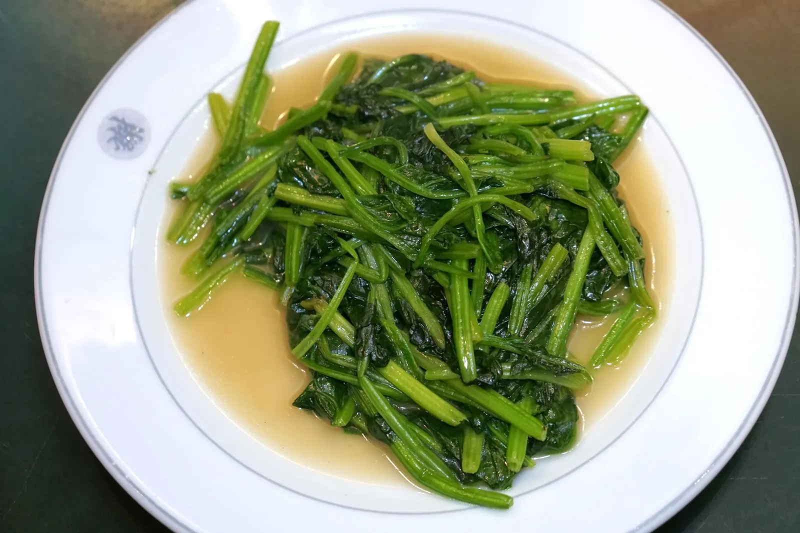 ปวยเล้งผัดน้ำมันหอย (60) Chinese spinach fried with oyster sauce “ปวยเล้งผัดน้ำมันหอย” เป็นจานผัดผักที่มีหน้าตาดูไม่ซับซ้อนแต่หากให้เราทำเองบอกเลยว่ารสชาติทำออกมาไม่ได้แบบนี้ เชฟแบงค์กระซิบว่าเคล็ดลับของจานนี้อยู่ที่การใช้กระทะเหล็กผัดที่ความร้อนสูงประกอบกับเทคนิคการใช้กระทะแบบจีนซึ่งจะทำให้ผักสุกโดยเร็วและยังมีความกรอบอยู่มาก น้ำมันหอยที่นี่รสชาติไม่ได้เข้มข้น แต่กลมกล่อมและไม่บดบังเนื้อสัมผัสของผักปวยเล้งเลยแม้แต่น้อย (13/20)
