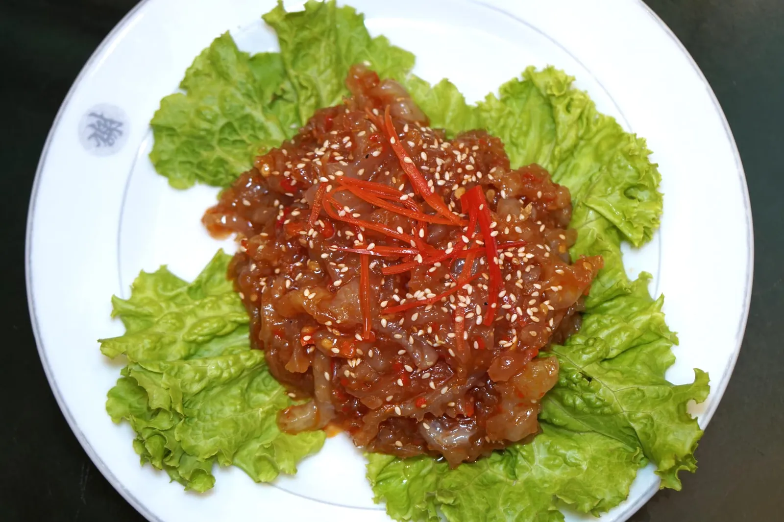 แมงกะพรุนน้ำมันงา (120) Jellyfish with sesame oil เริ่มต้นด้วยเมนูเด่นประจำห้องอาหารจีนแต้จิ๋วทุกร้าน และเป็นจานเรียกน้ำย่อยที่โดดเด่นที่สุดในค่ำคืนนี้คือ “แมงกระพรุนน้ำมันงา” เชฟใช้แมงกระพรุนคัดเกรดอย่างดีไปล้างด้วยน้ำส้มสายชู จากนั้นนำไปผ่านน้ำเปล่าเพื่อให้ความเปรี้ยวหายไป ต่อด้วยการหมักในเครื่องปรุงสูตรลับและราดน้ำมันงาลงไปจนส่งกลิ่นหอม เสิร์ฟมาแบบเย็น ทีเด็ดของจานอยู่ที่การใส่รสเผ็ดและความจัดจ้านซึ่งแฝงความเป็นไทยลงไปในอาหารแต้จิ๋วได้อย่างลงตัว เป็นจานที่แนะนำมากๆให้ทุกคนที่มาทาน ห้ามพลาดเด็ดขาด (14/20)
