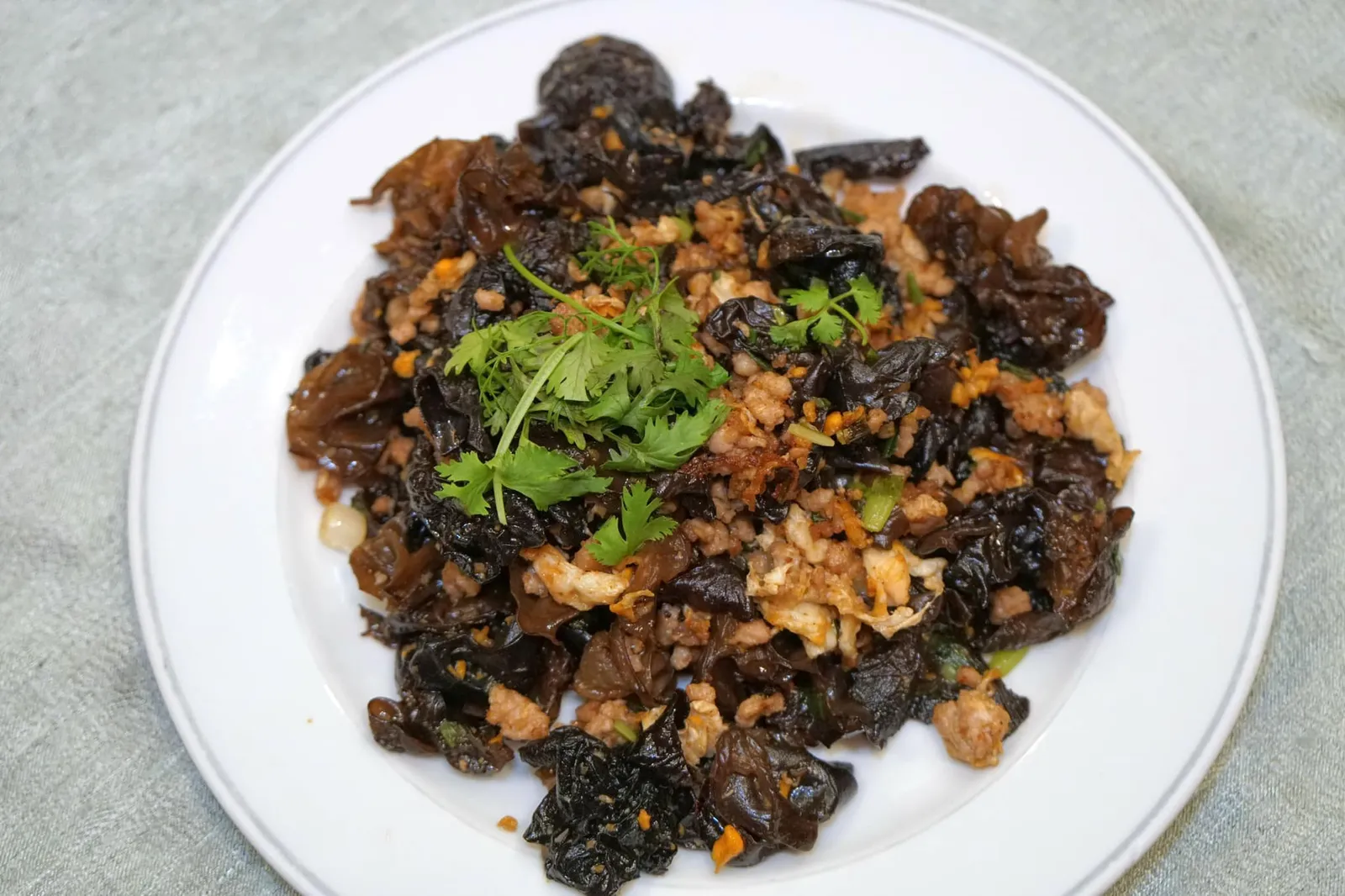 เห็ดหูหนูผัดไข่ (120) Jaw's ear fried with egg ขอปักหมุดจานที่ทำเอาเราตกใจและรู้สึกว้าวมากที่สุดในค่ำคืนนี้คือ “เห็ดหูหนูผัดไข่” ซึ่งเจี่ยท้งเฮงน่าจะเป็นร้านที่ทำเมนูนี้ออกมาได้ดีที่สุดในประเทศไทยแล้ว เชฟแบงค์ใช้สูตรดั้งเดิมอายุกว่า 63 ปีของอาม่า เริ่มจากการนำเห็ดหูหนูไปผัดในกระทะเหล็กแบบจีนขนาดใหญ่ เปิดไฟสูงแล้วค่อยๆเติมไข่ลงไปทำให้ทุกองค์ประกอบสุกโดยเร็ว เมื่อตักทานแล้วจะพบกับกลิ่นหอมกระทะเด่นชัดเจนมากๆ ไข่มีความกรอบนิดๆแต่ไม่แห้งและไม่อมน้ำมัน … เห็นจานใหญ่ขนาดนี้บอกเลยว่าอร่อยจนเราตักทานเกลี้ยงจานและมอบคะแนน 15/20 ให้ เทียบกับราคา 120 บาทที่ตั้งไว้ใครไม่สั่งถือว่าพลาดมากๆ (15/20)