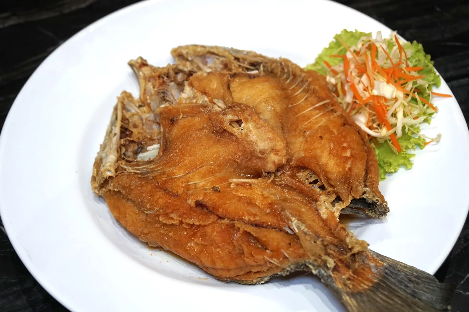ปลากะพงทอดน้ำปลา (500+) Deep fried sea bass with sweet fish sauce อีกหนึ่งเมนูเด็ดที่เราเป็นอันต้องสั่งทุกครั้งเมื่อมาทานที่นี่คือปลากะพงทั้งตัวที่นำไปทอดจนกรอบแต่เนื้อยังคงฟูนุ่ม ไม่อมน้ำมันแม้แต่น้อย เสิร์ฟมากับซอสที่ได้จากการผสมน้ำปลาชั้นดีกับน้ำตาบแล้วเคี่ยวในไฟอ่อนจนให้รสชาติหวานเค็มกลมกล่อม ทานกับข้าวสวยร้อนๆทอร่อยมากจริงๆ (13/20)