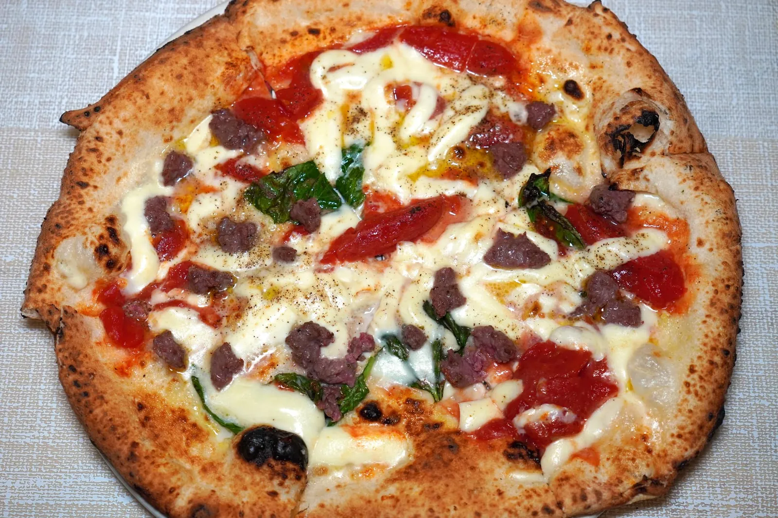 Capodimonte (11 €) San Marzano tomatoes cut in slices (e' pacchetelle), smoked buffalo mozzarella cheese, buffalo sausage, grated pecorino cheese, black pepper, extravirgin olive oil and basil Capodimonte คือพิซซ่าอันประกอบไปด้วยมะเขือเทศ San Marzano ตัดเป็นชิ้นใหญ่เข้าคู่กับความหอมของใบเบซิลและความมันของชีส Mozzarella ด้านบนมีรสชาติที่เข้มข้นของไส้กรอกเนื้อควายและอโรมาหอม ๆ ของพริกไทยดำ (15/20)