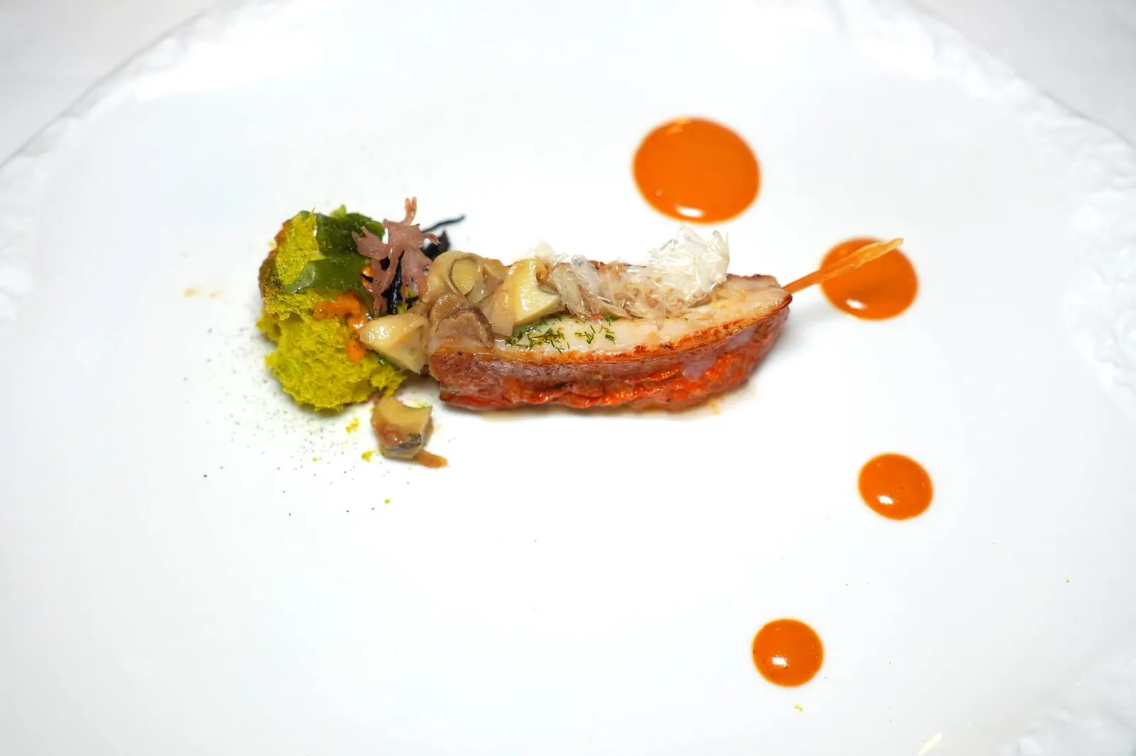 Red mullet cooked on the skin with its essence, scungilli and seaweed biscuit เมนูที่เสิร์ฟเคียงคู่กับห้องอาหาร Torre del Saracino มานานกว่า 19 ปีคือปลา Red Mullet เนื้อสัมผัสค่อนข้างเฟิร์ม ตรงกลางระหว่างชิ้นปลาทั้งสองเชฟสอดไส้ตับปลามาด้วย จากนั้นจึงเสิร์ฟมาคู่กับเกล็ดปลากรอบ ๆ ด้านบนท็อปด้วย Scungilli หรือเนื้อหอยสังข์ทะเลนุ่มหนึบ ข้างกันคือ Seaweed Sponge เนื้อสัมผัสเบาละมุนจับคู่กับ Seaweed-Sea Food Soup ที่มีส่วนผสมของสตูว์หอยสังข์ทะเล, หอยเม่น และดอกไม้ทะเลจนได้สีส้มช่วยเสริมกลิ่นอายของทะเลให้กับจาน เชฟแนะนำให้รับประทานคู่กันกับซอสสีส้มที่สกัดขึ้นมาจากส่วนต่าง ๆ โดยเฉพาะตับของตัวปลานั่นเอง (17/20)