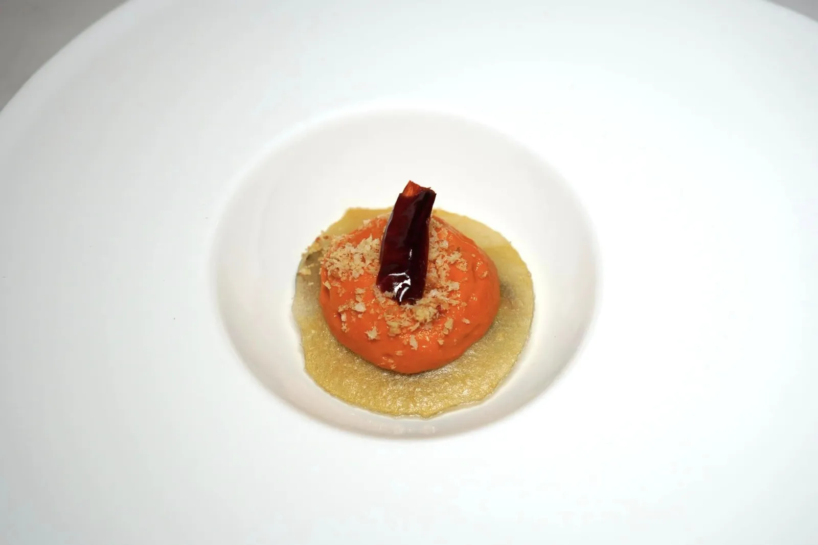 Nocerino spring onion cooked under ashes with papaccelle foam and cruschi peppers Nocerino Spring Onion เป็นต้นหอมสายพันธุ์ Allium Cepa L. ที่เพาะปลูกกันมากบริเวณเนินเข้าฝั่งใต้ของภูเขาไฟ Vesuvius มานานกว่า 2,000 ปี ในที่นี้เชฟนำไปปรุงให้สุกด้วยขี้เถ้าท็อปด้านบนด้วย Papaccelle Foam หรือโฟมที่เตรียมมาจากพริกหวาน Neapolitan ท้องถิ่นให้อโรมาหอมเฉพาะตัวและเนื้อสัมผัสของโฟมที่เบาละมุนตัดกันกับความกรอบของแผ่น Parmesan Waffle ยังมีองค์ประกอบของ Peperone Crusco ซึ่งเป็นพริกแห้งขึ้นชื่อให้กลิ่นหอมและรสขมเบา ๆ ท็อปมาที่ด้านบนสุดอีกด้วย (17/20)