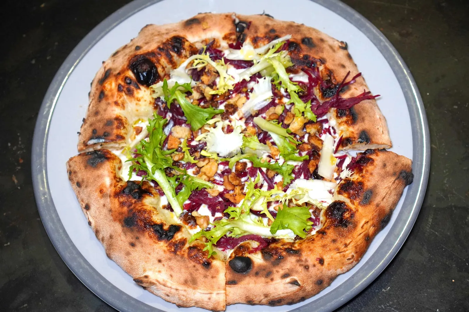 MANGIABUFALO Fabula buffalo cheese cream, fiordilatte cheese, toasted bread with Balsamico Modena IGP vinegar, walnuts, buffalo bresaola, raw frisée EVO oil Mangiabufalo เป็น Innovative Pizza ที่นำเสนอครีมชีสนมควาย Fabula ผสมผสานเข้ากับความหอมและความครีมมี่ซุ่งเป็นเอกลักษณ์ของชีส Fior di Latteนอกจากนี้ยังมีมิติทางเสิ้อสัมผัสอันหลากหลายทั้งความนุ่มหนึบของ Bresaola เนื้อควาย ความกรอบของถั่ว Walnuts และขนมปังกรอบที่ปรุงรสด้วยน้ำส้มสายชู Balsamic จากนคร Modena ในแคว้น Emilia-Romagna แล้วจบด้วยการเทราดน้ำมันมะกอก EVO ดิบลงไปนั่นเอง (15/20)