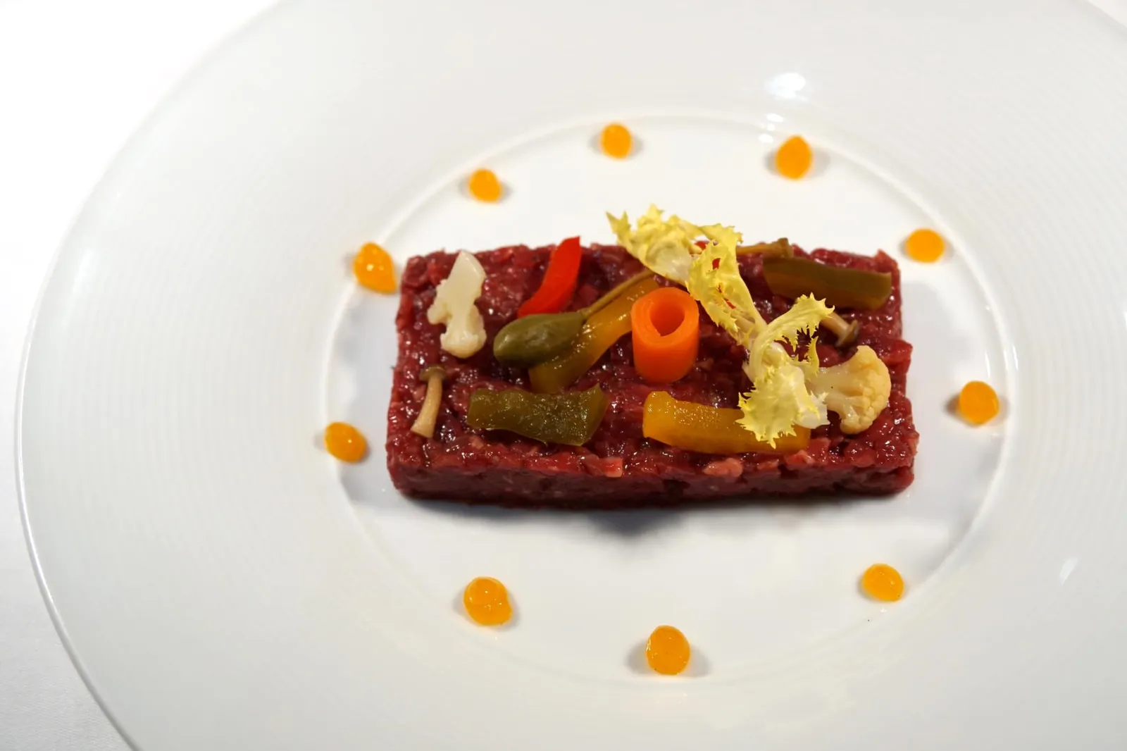 Tartara di Wagyu, Giardiera Fatta in Casa e Salsa Tuorlo Marinato (590++) Wagyu Beef Tartar, Home Pickled Vegetables & Cured Egg Yolk Sauce ทาทาร์เนื้อวัววากิว อาหารเพียงหนึ่งเดียวในวันนี้ที่เป็นเมนูตามฤดูกาล เนื้อทาทาร์ถูกเตรียมมาอย่างดีสังเกตได้จากการสับเนื้อจนละเอียดเเต่ไม่เละ เนื้อวัวเนียน นุ่ม มีส่วนมันมากกว่าทาทาร์เนื้อทั่วไป ด้านบนคือผักดองนานาชนิดให้รสเปรี้ยวเพื่อตัดความมันไม่ให้เกิดการเลี่ยนได้ง่าย ซอสสีส้มรอบๆทำมาจากไข่แดงหมัก มีรสมันๆเค็มๆ ถือเป็นจานทาทาร์ที่ดีมากจานหนึ่งเลยทีเดียว (13/20)