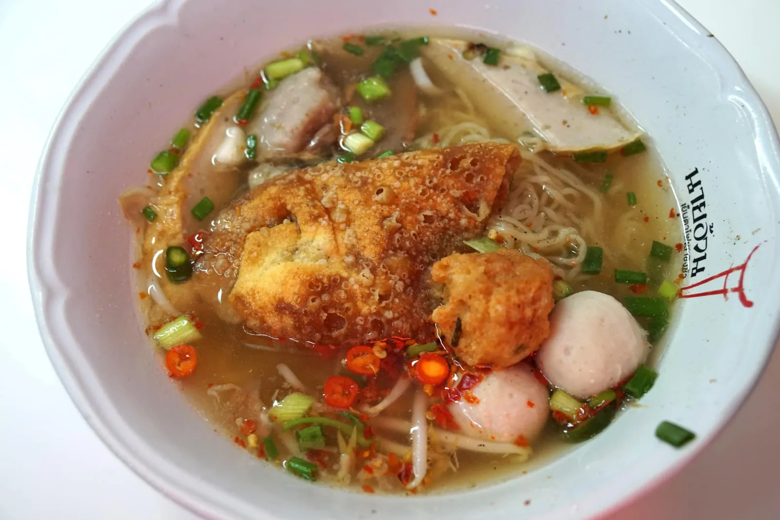 บะหมี่น้ำต้มยำลูกชิ้นปลา (60) บะหมี่ต้มยำมีรสเผ็ดถึงเครื่อง เเต่ไม่เผ็ดจนกลบรสเปรี้ยวหวานมันเค็ม เส้นบะหมี่ไม่เเข็ง เเต่ก็ไม่นุ่มจนเกินไป ลูกชิ้นกุ้งที่นี่ผสมมันหมูเข้าไปด้วยทำให้มีกลิ่นหอมของทั้งหมูเเละกุ้ง ทัง้ยังมีความมันไม่เหมือนใคร ส่วนลูกชิ้นปลาที่ทำมาจากเนื้อปลาแท้ๆก็เนื้อเด้ง อร่อยไม่แพ้กัน ถือเป็นร้านก๋วยเตี๋ยวที่ดีเลิศเป็นอันดับต้นๆของกรุงเทพเลยทีเดียว (14/20)