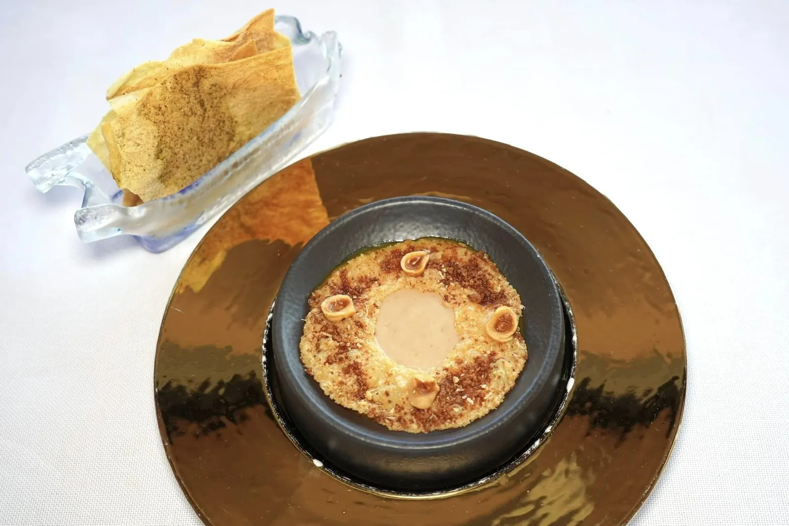 A tasty little starter เริ่มต้นมื้ออาหารด้วยของว่างเรียกน้ำย่อยอย่างครีมที่เตรียมมาจากเกาลัดและฟักทองให้รสชาติหวานละมุนรองอยู่ด้านล่าง ด้านบนคือวงแหวนทำมาจากชีส Grana Padano และถั่วฮาเซลนัทให้ความกรอบ ข้างกันคือ Pane Guttiau หรือขนมปังบาง ๆ จากภูมิภาค Sardinia อบมาเพียงไม่กี่นาทีจนกรอบนั่นเอง