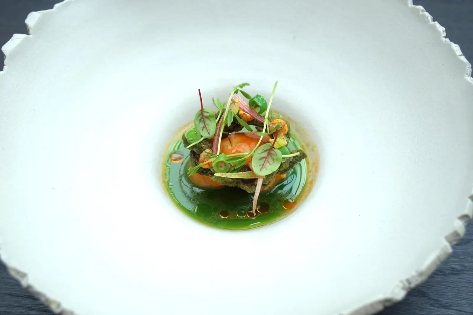 Langoustine, tomato, kombucha, snake beans ถัดมาคือ “Langoustine” ที่เชฟจัดเตรียมมาในสไตล์ Ceviche โดยปกติการทำเซวิเช่จะใช้กรดจากผลไม้รสเปรี้ยวเช่นมะนาวบีบลงไปเพื่อสะดุ้งทำให้เนื้อหรือโปรตีนหลักมีความเด้งมากขึ้นคล้ายอาหารสุก แต่สำหรับ De Librije ร้านระดับ 3 ดาวมิชลินจะเสิร์ฟเซวิเช่แบบปกติก็คงไม่ได้ … จานนี้เชฟใช้ Kombucha หรือน้ำชาหมักของประเทศญี่ปุ่นซึ่งมีค่า pH เป็นกรดอ่อนๆมาสะดุ้งผิวของแลงกูสทีน ตอนทานจะได้ความนุ่ม เด้ง และรสหวานธรรมชาติซึ่งเป็นจุดเด่นของกุ้งชนิดนี้มาแบบเต็มๆ ด้านบนมีถั่วฝักยาวหั่นเป็นชิ้นเล็กๆเพิ่มความกรุบกรอบเพิ่มมิติทางเนื้อสัมผัสให้กับจาน (19/20)