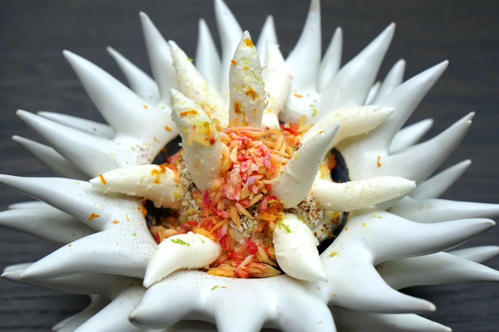 Blood orange, coconut, peanuts ขนมหวานจานสุดท้ายหน้าตาดูทั้งประหลาดทั้งตลกจนเราต้องถามตัวเองว่า กินได้จริงไหม เชฟทำขนมออกมาให้มีรูปร่างล้อกันไปกับถ้วย โดยตัวขนมจะแบ่งออกเป็นเลเยอร์หลายชั้น เริ่มจากชั้นล่างสุดทำมาจากส้มบลัดออเร้นจ์ เลเยอร์ตรงกลางทำมาจากถั่วลิสง ส่วนที่เหลือทำมาจากมะพร้าว ส่วนหนามด้านนอกเป็นเมอแรงก์กรอบ ตอนทานต้องตักให้ลึกถึงด้านล่างเพื่อให้ในหนึ่งคำมีทุกองค์ประกอบ (19/20)