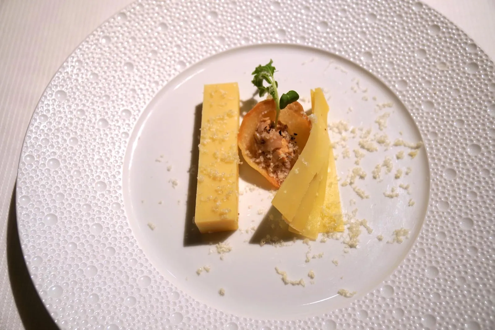 Matured cheeses and / or a preparation of cheese Fromages affinés et/ou la préparation “กอมเต้” ชีสนมวัวที่เป็นหนึ่งในสัญลักษณ์ทางอาหารของประเทศฝรั่งเศสที่ผ่านการบ่มนาน 36 เดือนจนได้เนื้อสัมผัสและรสชาติที่ดี จากนั้นจึงเสิร์ฟมาโดยรักษาความเป็นธรรมชาติของตัวชีสให้ได้มากที่สุด ฝั่งซ้ายมือเป็นแท่งชีสทรงสี่เหลี่ยมผืนผ้า ส่วนฝั่งขวามือเป็นชีสที่ฝานมาเป็นแผ่นบาง ๆ ทั้งคู่ให้เนื้อสัมผัสที่แตกต่างกันออกไป รอบ ๆ เป็นผงชีส ส่วนองค์ประกอบตรงกลางคือ Croustillant ที่มี Mushroom cream หรือครีมเห็ดอยู่ด้านใน (20/20)