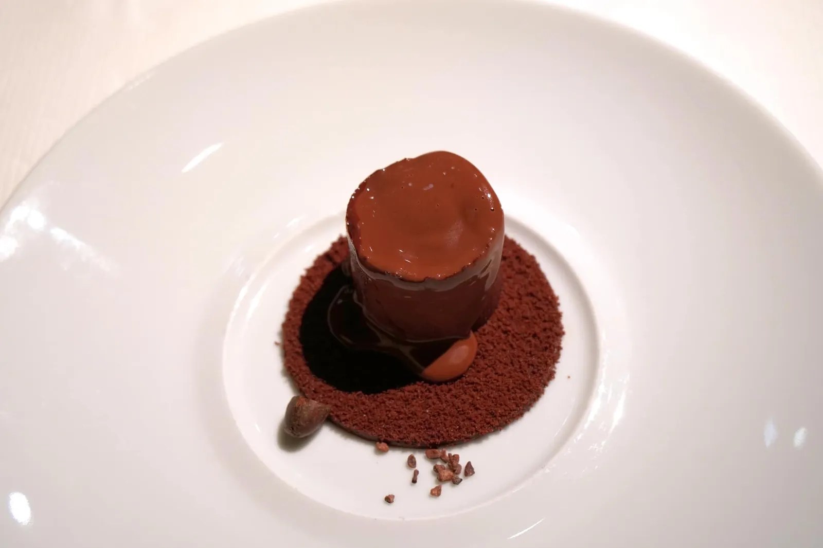 Pure chocolate Purement chocolat A crisp tube concealing a dark chocolate mousse, cacao sorbet and a sea salt biscuit, served with a warm chocolate sauce. ก่อนทานพนักงานจะเทราดซอสร้อน ๆ ลงไป อย่าลืมตักให้ลึกถึงชั้นล่างเพื่อสัมผัสถึงอุณหภูมิที่แตกต่างกันของซอสร้อน ๆ และซอร์เบท์เย็น ๆ ยังมีมูสช็อกโกแลตเนื้อนุ่มละมุน รสชาติทุกองค์ประกอบเข้มข้น เสริมด้วยความเค็มของคาราเมลจาก Opaline แผ่นคริสปี้ทรงกระบอกและครัมเบิ้ลกรอบช่วยสร้างมิติทางเนื้อสัมผัส บิสกิตด้านล่างมีรสเค็มที่ดีจาก Fleur de sel หรือดอกเกลือทะเล จัดเป็นเมนูที่นำเสนอความสวยงามทางรูปลักษณ์ ความซับซ้อนทางเนื้อสัมผัส ความบริสุทธิ์ของช็อกโกแลต ผสานเข้ากับประวัติศาสตร์ของสถานที่ออกมาได้อย่างไร้ที่ติ (20/20) สำหรับเทคนิคการทำขนมชิ้นนี้โดยละเอียด เพื่อน ๆ สามารถตามไปชมได้ที่: https://yam.paris/la-monnaie-de-paris-version-chocolat/