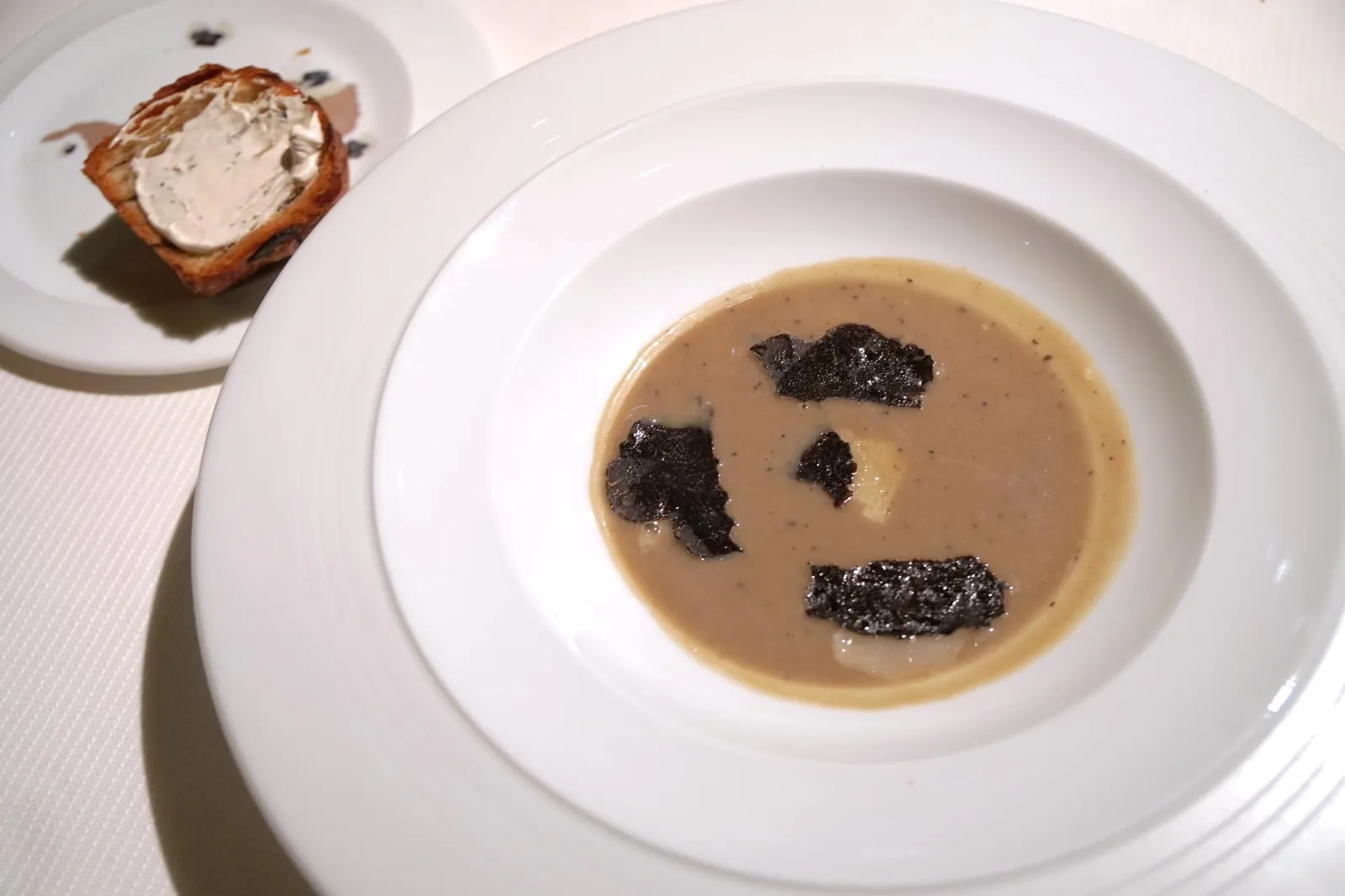 Artichoke soup with black truffle; layered truffled mushroom brioche and more... Soupe d'artichaut à la truffe noire, brioche feuilletée aux champignons et truffes, et encore plus… Artichoke soup, black truffle and Parmesan shavings; layered mushroom brioche spread with truffle butter. ว่ากันว่าสาเหตุที่ Artichoke soup กลายเป็นสัญลักษณ์ประจำตัวของเชฟ Guy Savoy อันเนื่องมาจากตัวเชฟเองเมื่อครั้งยังเด็กนั้นชื่นชอบอาติโชคพูเรมากเป็นพิเศษถึงขนาดทานเป็นอาหารหลัก (20/20)