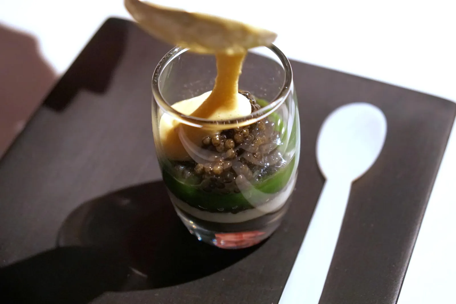 'Colours of caviar', with smoked sabayon Colors of caviar, sabayon fumé dans l'œf Caviar cream, caviar vinaigrette and a purée of Savoy cabbage; served with Royal and Baeri caviars and a smoked sabayon. พนักงานจะเทซาบายอนทอปลงไปบนคาเวียร์ ข้าง ๆ ถ้วยคือช้อนทำจากเปลือกหอยสำหรับตักคาเวียร์นั่นเอง (20/20)
