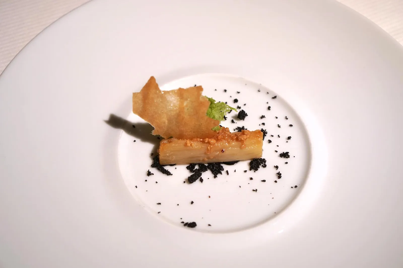 Confit salsify in a hazelnut crumb: a stroll through the forest Le confit de salsifis en panure de noisettes comme un sous-bois Seared confit salsify filled with a creamed salsify purée; vegetable 'earth' and parsley sponge with roasted hazelnuts. เมนูอาหารคาวจานสุดท้ายคือ “ซัลซิฟาย” ที่ผ่านการกงฟีจนนุ่มแล้วจึงนำมาเซียต่ออีกทีหนึ่ง ด้านในมีครีมของซัลซิฟาย ด้านบนทอปด้วยถั่วฮาเซลนัทย่าง Sponge รอบ ๆ สีเขียวทำมาจากพาสลีย์และสีดำทำมาจากผักรากช่วยเพิ่มความหลากหลายทางเนื้อสัมผัส (18/20)