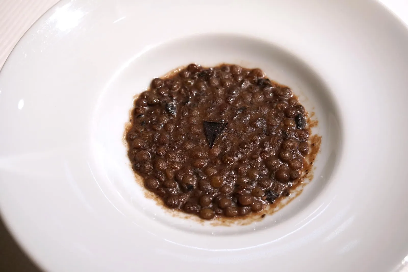 Ragù of black lentils with black truffle Ragù de lentilles noires à la truffe noire คั่นกลางด้วยจานที่ไม่มีในเมนูอย่างรากูของถั่วเลนทิลและแบล็คทรัฟเฟิล ตักทานแล้วจะได้เนื้อสัมผัสค่อนข้างหยาบซึ่งเป็นธรรมชาติของถั่วเลนทิล มีกลิ่นหอมของเห็ดทรัฟเฟิลเด่นชัดเจน (18/20)