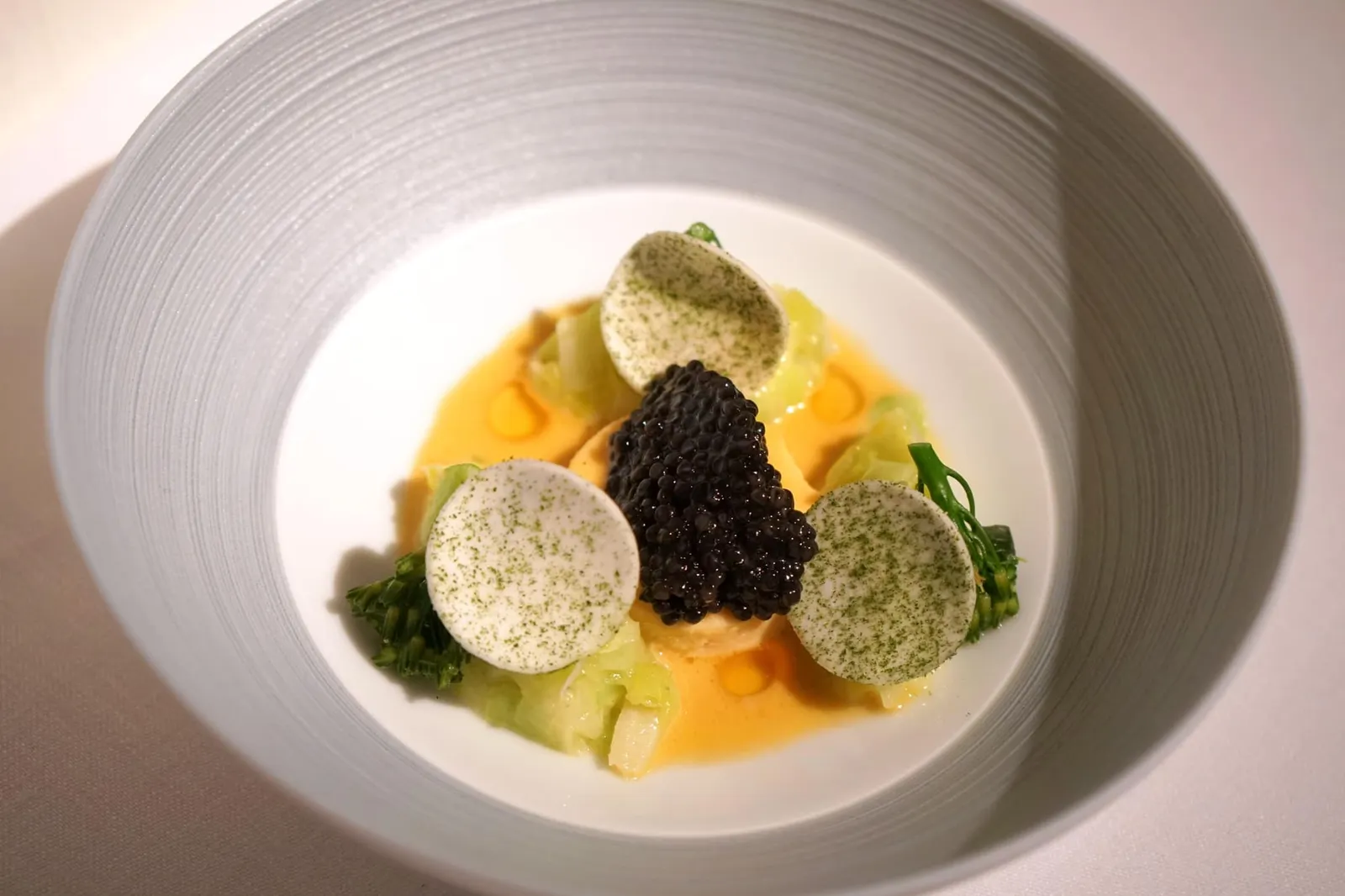 CAVIAR 'HOF VAN CLEVE - IMPERIAL HERITAGE' brown shrimp • leek • beurre blanc เชฟเริ่มต้นจากการนำ Brown Shrimp หรือกุ้งสีน้ำตาลไปทำเป็น Flan เนื้อนุ่มละมุน (ชิ้นสีส้มในภาพ) เสิร์ฟมาให้ทานคู่กับกระเทียมต้น เห็ดนำเข้าจากฝรั่งเศสและ Bimi broccoli ซึ่งเป็นพืชตระกูลบล็อคโคลี่ขนาดจิ๋ว จับคู่กับคาเวียร์ชั้นดี ทุกองค์ประกอบเข้ากันกับฟลานกุ้งได้อย่างไร้ที่ติจนได้รับการยกย่องให้เป็นหนึ่งในจานคาเวียร์ที่ดีที่สุดในโลกเลยก็ว่าได้ (20/20)