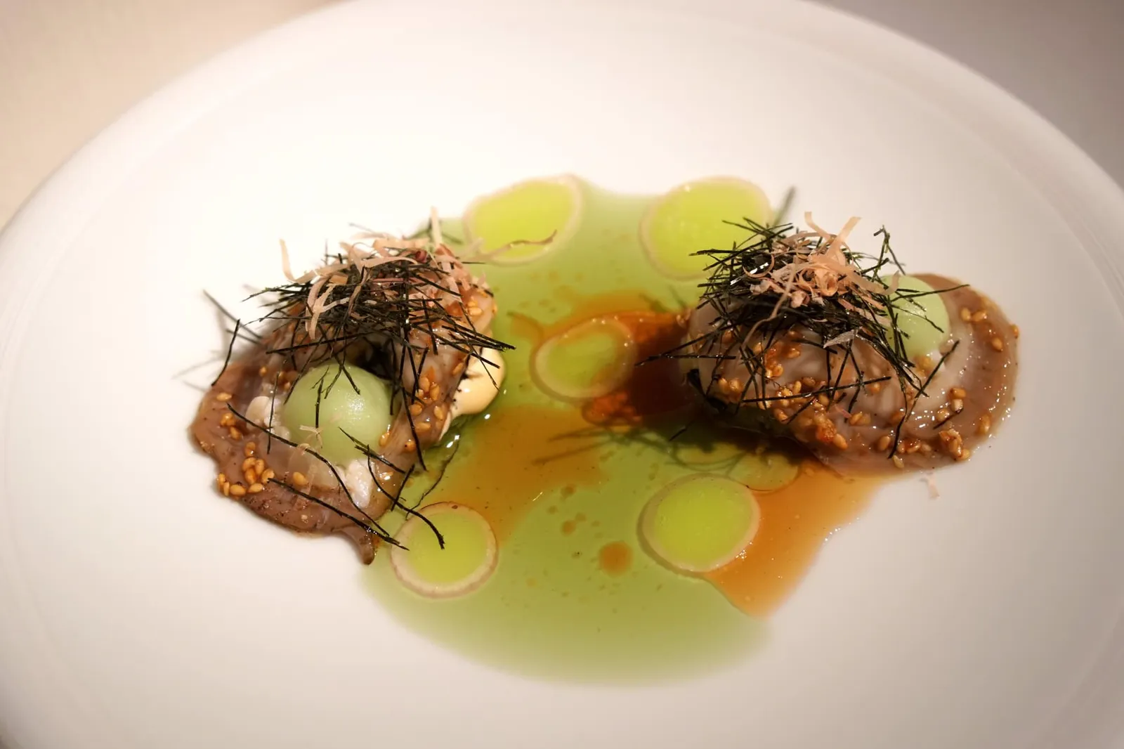 NATIVE OYSTER FROM ZEELAND 6/0 apple • sesame • hijiki เมนูแรกในคอร์สหลักคือ Black Oyster หรือ “หอยนางรมพื้นเมืองเบอร์ 6/0” จากน่านน้ำเขต Zeeland คลุกมากับงาขาว ด้านบนทอปด้วย Hijiki ซึ่งเป็นพืชทะเลชนิดหนึ่งจากประเทศญี่ปุ่น องค์ประกอบกลม ๆ คือซอร์เบท์แอปเปิ้ลเขียว จากนั้นพนักงานจะเทซอส Ponzu Vinegar ลงไปให้รสอมเปรี้ยวนิด ๆ ช่วยเรียกความสดชิ่นได้เป็นอย่างดี (19/20)