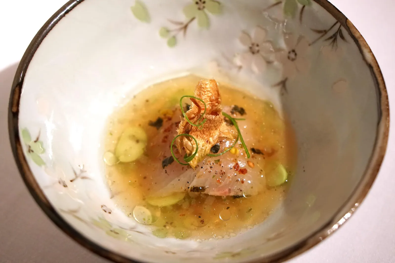 YELLOW FIN MACKEREL cucumber • soy ที่ห้องอาหาร Hof van Cleve เชฟ Peter Goossens มีความชื่นชอบในการนำวัตถุดิบจากญี่ปุ่นมาผสมผสานกับเทคนิคของอาหารฝรั่งเศสจนออกมาเป็นเมนูที่มีอัตลักษณ์เป็นของตัวเอง ในจานนี้เราจะได้ลิ้มลอง “เนื้อปลาฮามาจิ” สด ๆ นำเข้าจากญี่ปุ่นให้เนื้อสัมผัสนุ่มหนึบแล้วทอปด้านบนด้วยปลาแห้งให้เนื้อสัมผัสเคี้ยวกรอบแตกต่างกัน ดาชิด้านล่างมีกลิ่นหอมของแตงกวาเบา ๆ แต่ไม่มีกลิ่นเขียวติดมาแม้แต่น้อย อีกหนึ่งองค์ประกอบสำคัญคืองาที่ช่วยแต่งเติมกลิ่นหอมให้เด่นชัดขึ้นมากและแฝงกลิ่นอายความเป็นญี่ปุ่นเอาไว้ได้อย่างแนบเนียน (20/20)