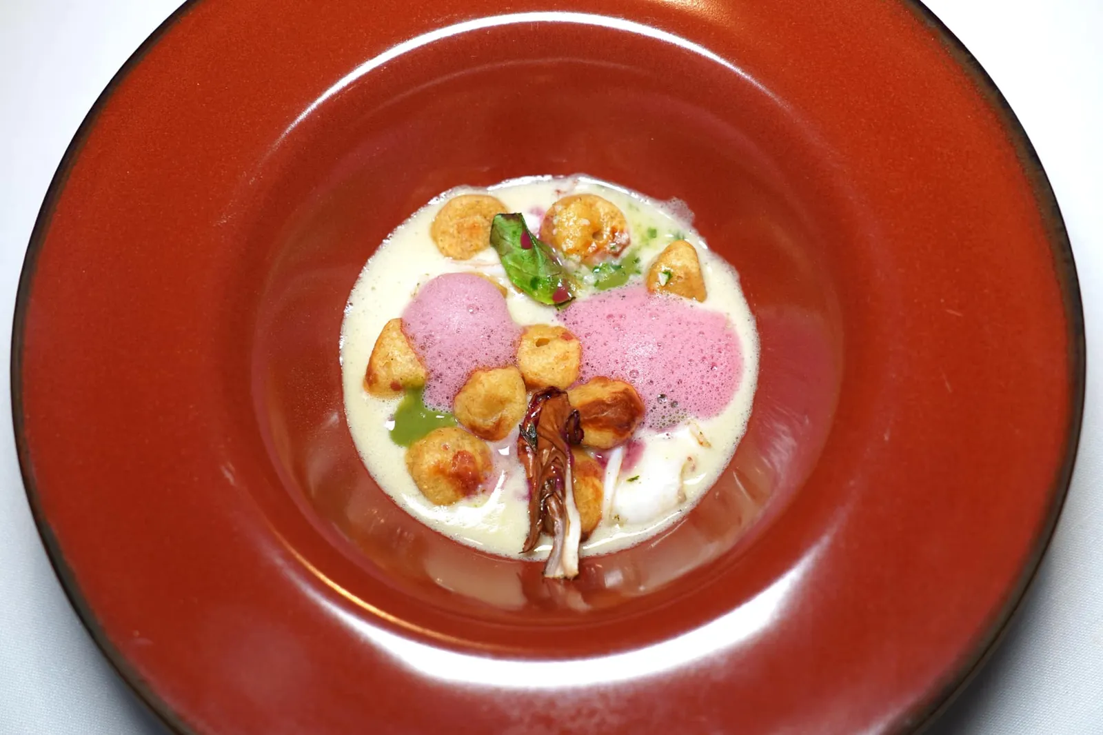 GNOCCHI MADE WITH BREAD, BABY SQUIDS MILK AND VERMOUTH fennel sauce, lemongrass and pomegranate Gnocchi ที่ผ่านการย่างสองครั้งในเตาอบและบนเตาขนมปังจนได้เนื้อสัมผัสกรอบ เบา แทนที่มันฝรั่งนุ่ม ๆ แบบดั้งเดิม ด้านล่างคือน้ำนมที่เตรียมมาจากหมึกไซซ์จิ๋วโดยมีอโรมาหอม ๆ ของ White Vermouth เสริมอยู่ด้วย เชฟป้องกันไม่ให้เกิดการเลี่ยนโดยการใส่ซอสเฟนเนล, ซอสตะไคร้ และโฟมทับทิมสีชมพูสดใสลงไปด้วย (17/20)