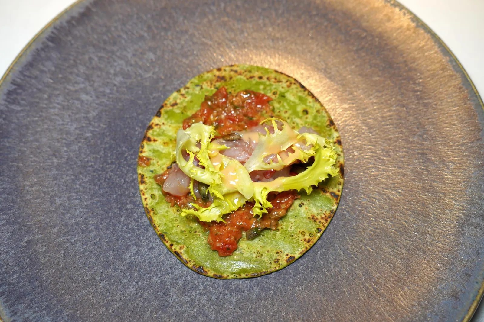 PLANKTON TORTILLAS lobster in cooking oil, roasted pumpkin seeds, salmoriglio sauce and caramelized lobster แผ่นแป้ง Tortillas ที่ได้สีเขียวมาจากแพลงก์ตอนทะเลก่อนจะนำไปย่างจนสุกพอดี ตรงกลางบรรจุเนื้อกุ้งล็อบสเตอร์สองรูปแบบทั้งส่วนที่ดิบและส่วนที่ผ่านการผัดมาเล็กน้อยแต่ยังคงเนื้อสัมผัสที่นุ่มและฉ่ำเอาไว้ได้อย่างครบถ้วน จากนั้นเสิร์ฟมากับซอส Salmoriglio สไตล์ Sicily นอกจากนี้ยังมีมิติทางเนื้อสัมผัสจากการใส่เมล็ดฟักทองคั่วลงไปอีกด้วย (18/20)