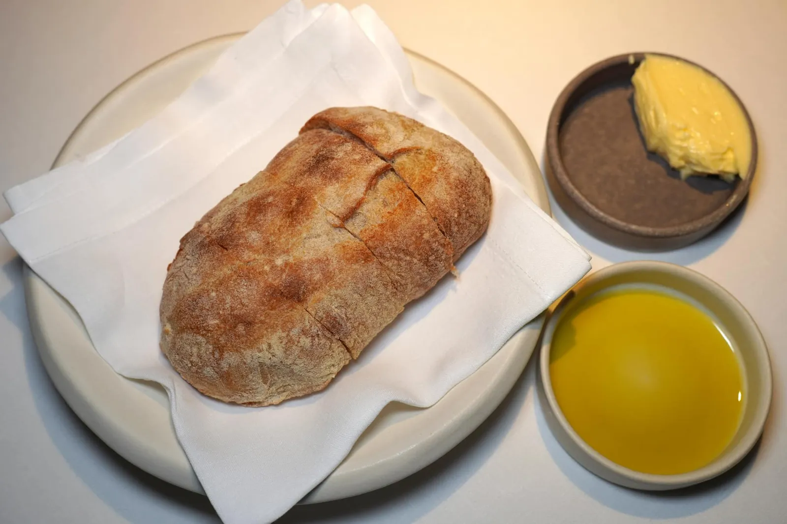 BREAD จากนั้นพนักงานจะนำเสิร์ฟขนมปังมาคู่กับเนยจากแคว้น Normandy ประเทศฝรั่งเศสและน้ำมันมะกอกที่เพิ่งเก็บเกี่ยวในปี 2022 จากเมือง Bassano del Grappa ห่างออกไปจากตัวร้านเพียงไม่กี่กิโลเมตรเท่านั้น