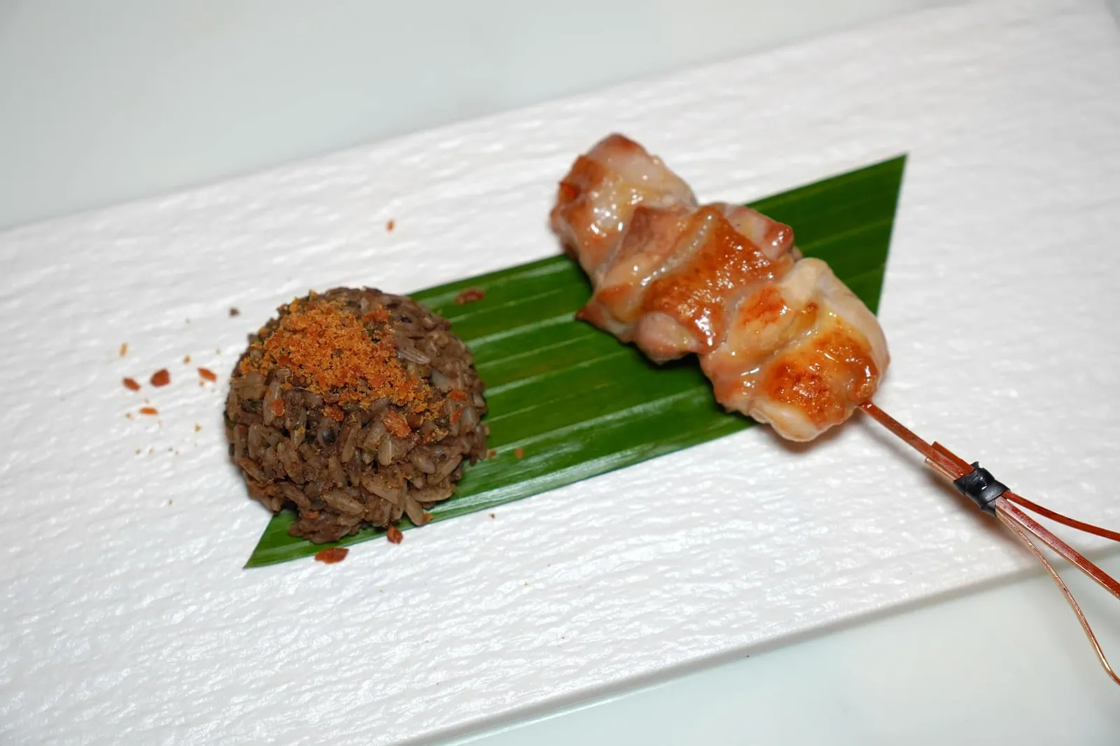 ร้อนรสโอชเอม (ข้าวคลุกน้ำพริก พริกไทยอ่อน-ไก่ย่าง) (~700 ปี) Grilled Chicken and Fried Rice with Green Peppercorn Paste เชฟจึงหยิบองค์ประกอบตรงนี้นำเสนอมาโดยการนำไปคลุกกับข้าวให้รสชาติเผ็ดจัดจ้านและมีกลิ่นหอมชวนชิม ด้านบนท็อปด้วยปลาแห้งที่เตรียมขึ้นมาจากปลาช่อนแม่ลา ข้างกันคือไก่ย่างตะนาวศรีที่มีเนื้อสัมผัสนุ่มหนึบ ไร้ซึ่งความเหนียวให้รับประทานไปพร้อม ๆ กัน (13/20)